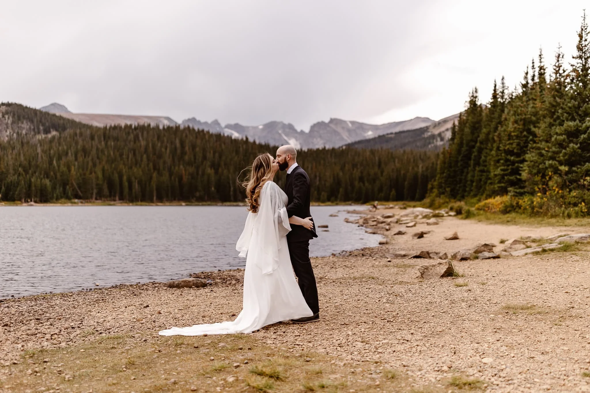 All stood still as the two said I do and shared their first kiss as husband and wife. The bride's gossamer sleeves are lightly blowing in the wind and it's a beautiful moment.
