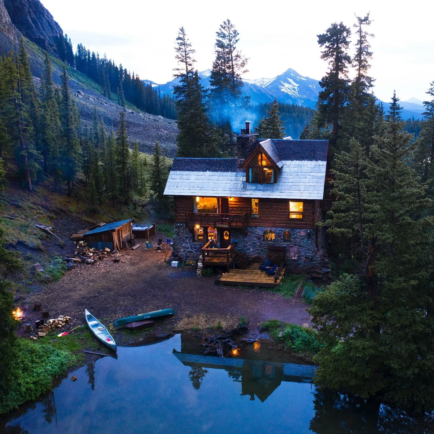 An aerial view of The Observatory at Alta Lakes, showing the cabin, lake, and mountains that make this place so magical.