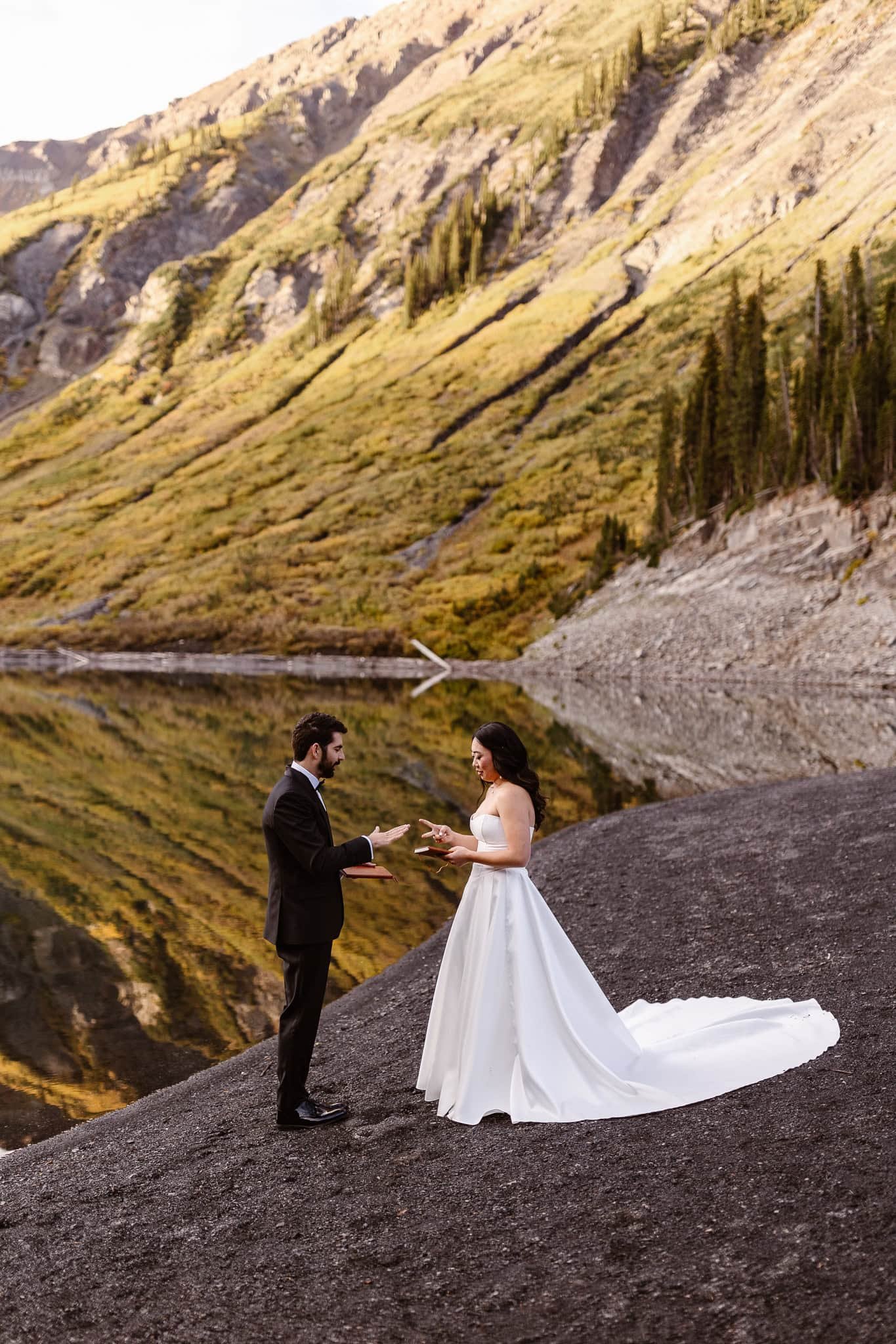 As the sun begins to kiss the lush green mountains behind them, the bride and groom play rock, paper, scissors to decide who reads their private vows first.