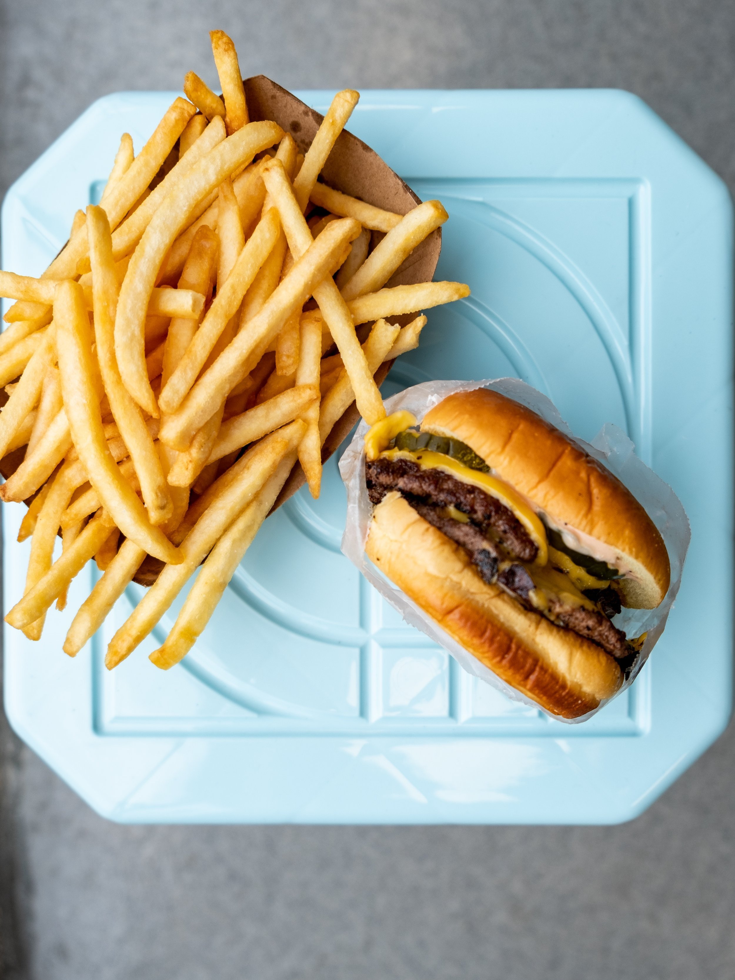  a burger and french fries on a blue stool 