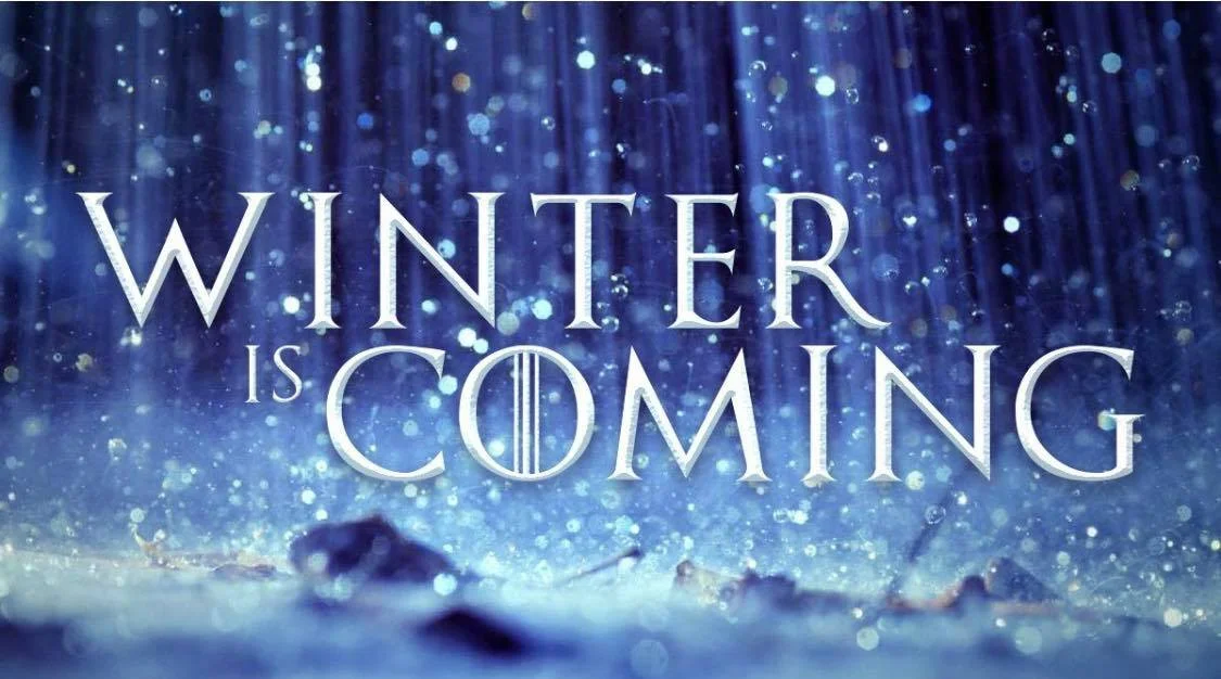 Photo ID: a snowy and glitter blue background with the words “winter is coming” in the center
