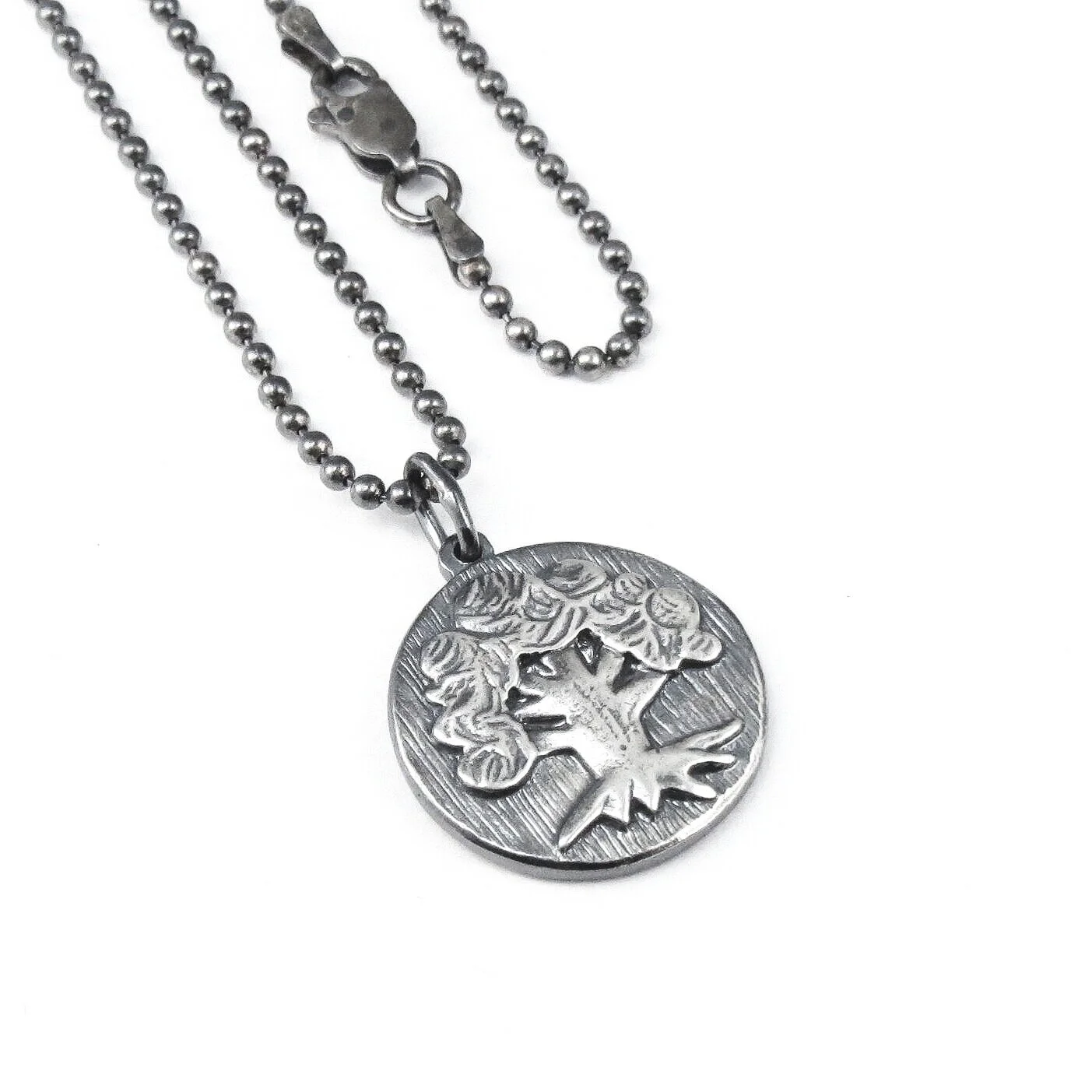Green Mana pendant on silver ball chain necklace on a white background.