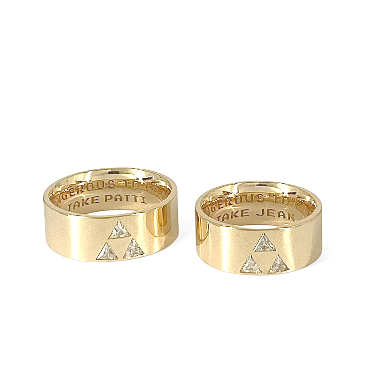 2 yellow 10karat yellow gold rings with 3 triangular cut Moissanite stones set in a triangular formation and inside engaving: IT'S DANGEROUS TO GO ALONE. TAKE PATTI and TAKE JEAN.