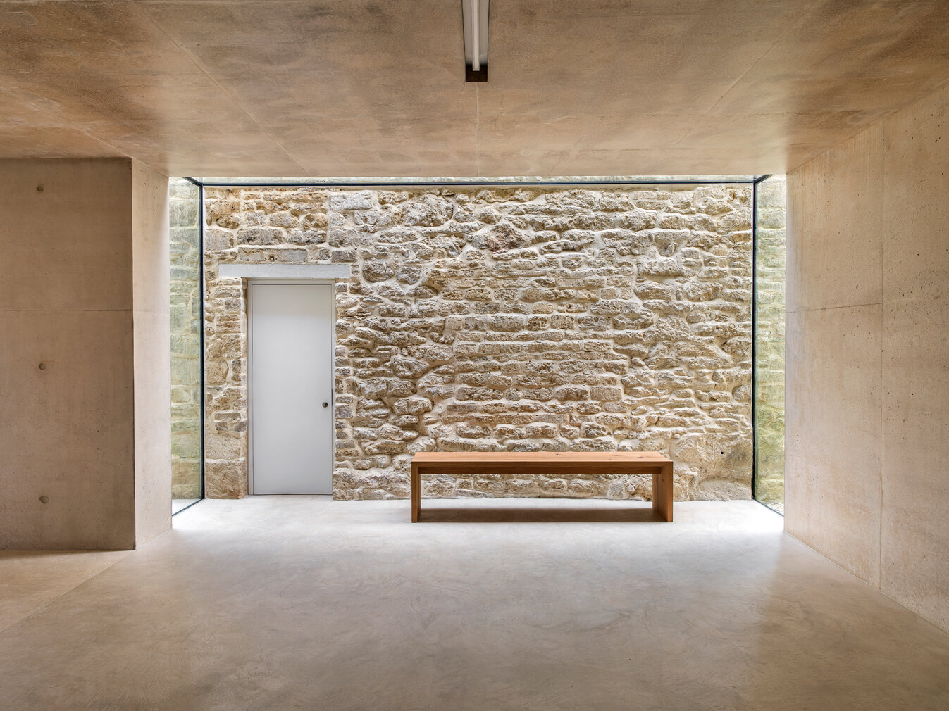 Found-House-the-old-Cotswold-cottage-wall-contrasts-with-the-smooth-concrete-of-the-extension.jpg