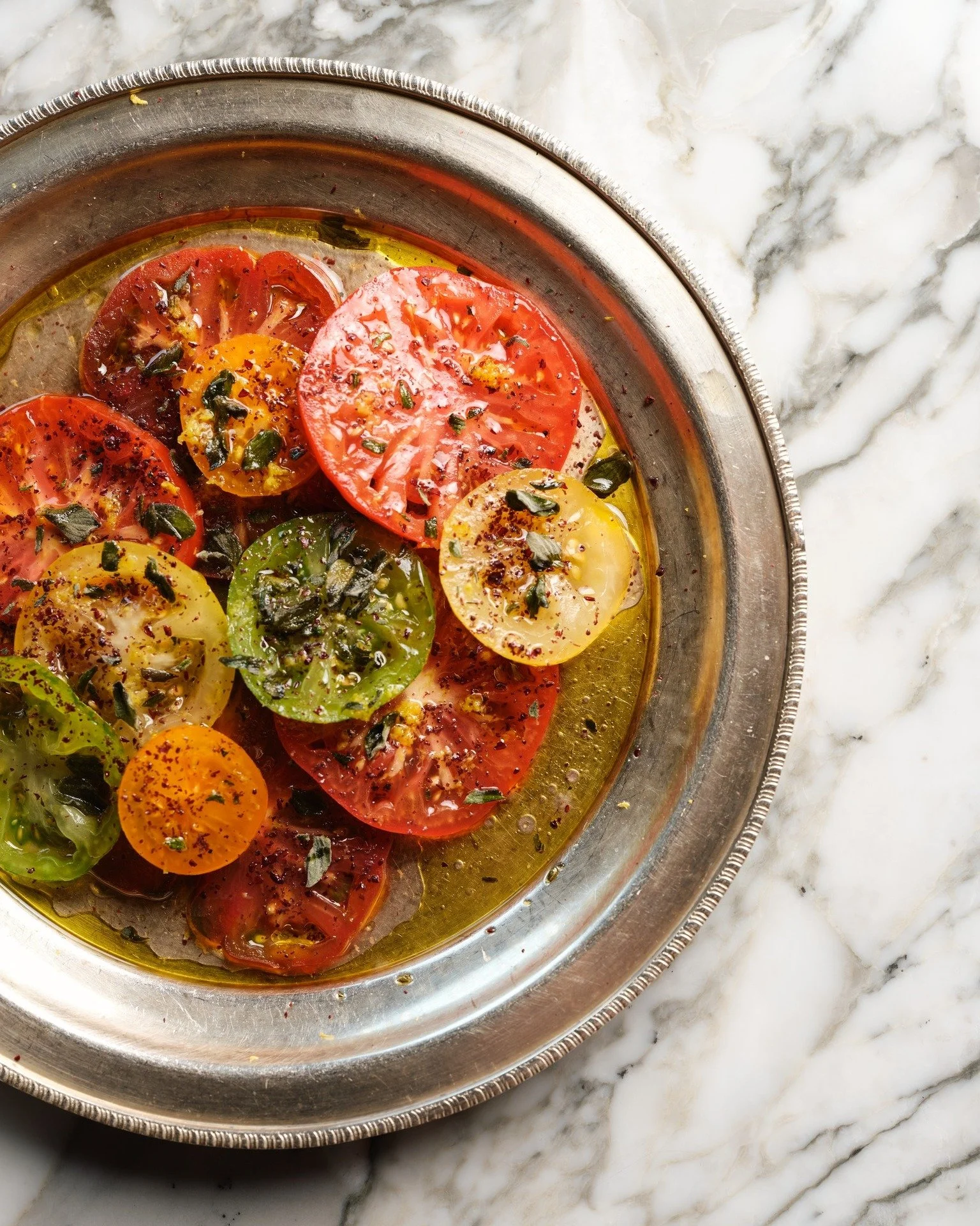 Our iconic heirloom tomatoes, topped with roasted garlic, served with Berenjak's Barbari. #BERENJAKxTHEMAINE

 #TheMaine #TheMaineDXB