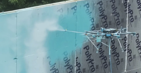 Drone spraying a coating onto an exterior wall