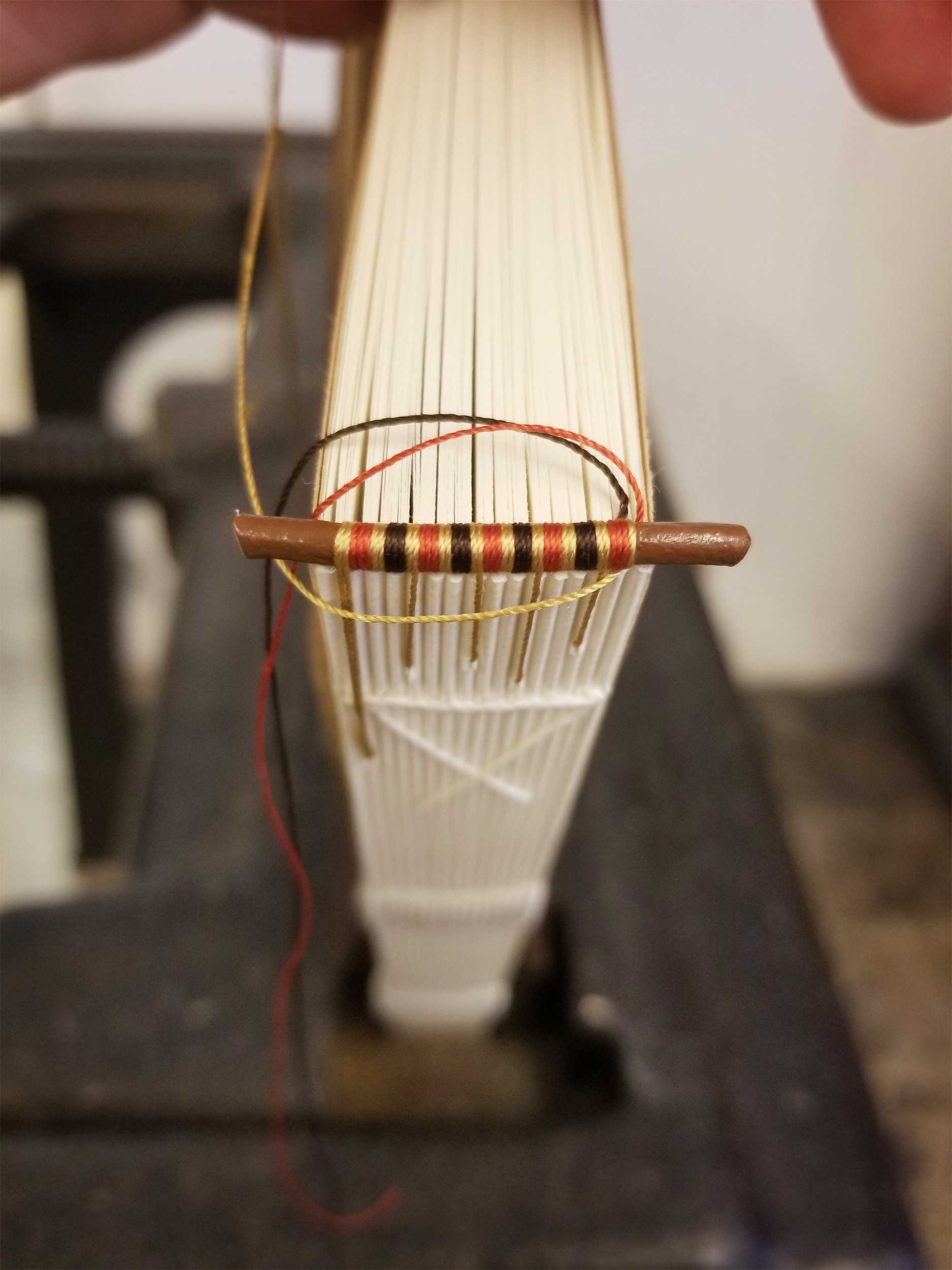 Hand-sewing a headband on the Arion Press edition of Eugene Onegin