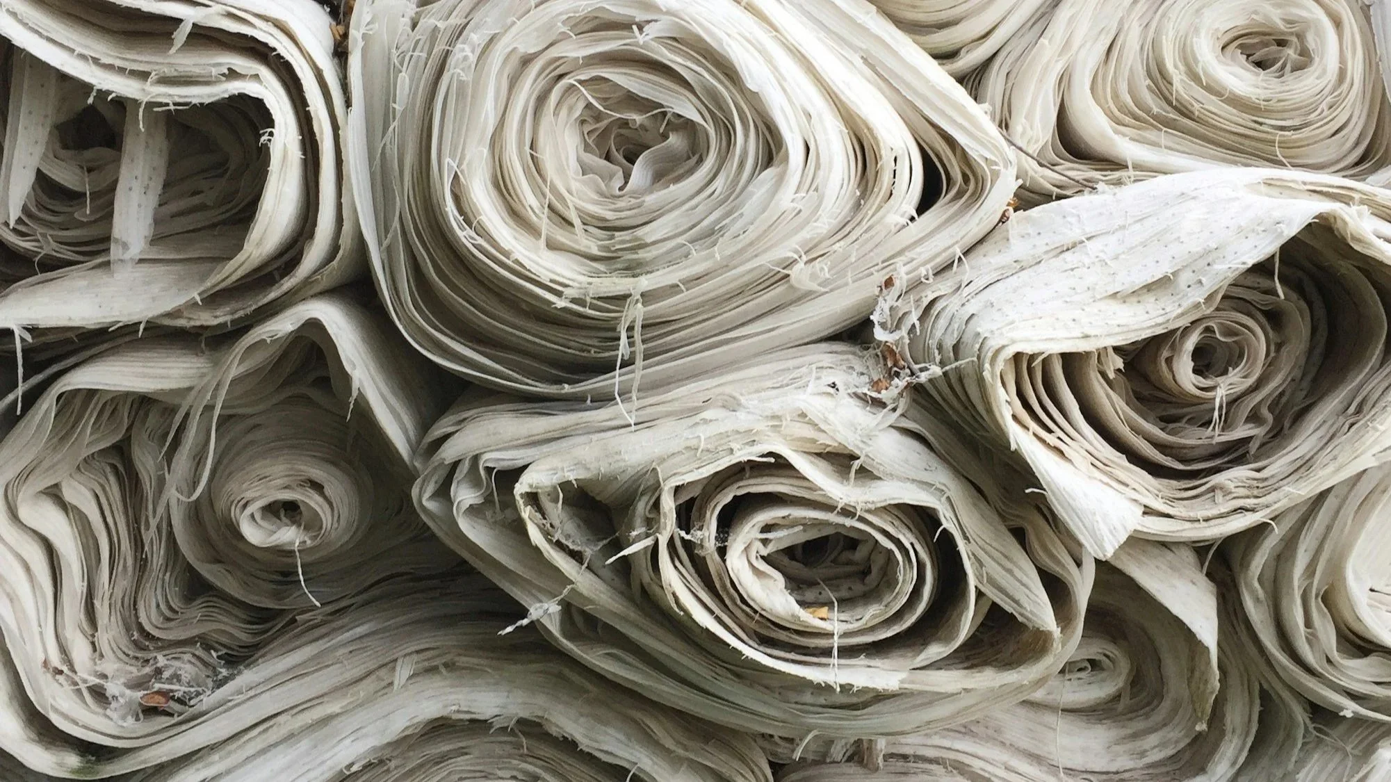 Image features rolls of undyed natural linen fabric