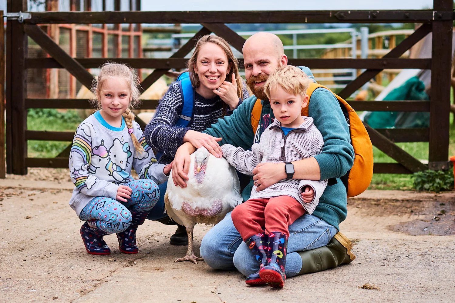 A family petting a rescued turkey at a sanctuary