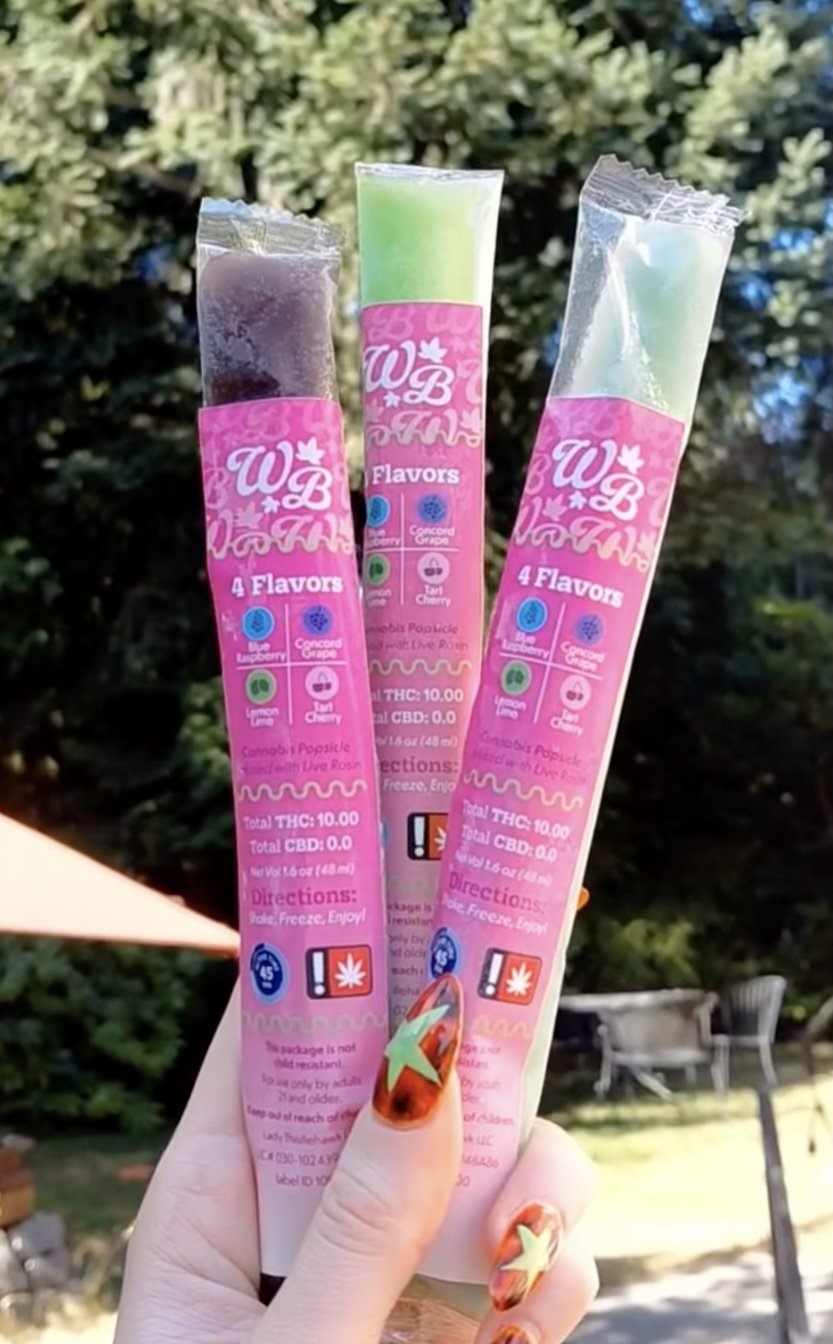 Image of hand holding three cannabis infused popsicles.