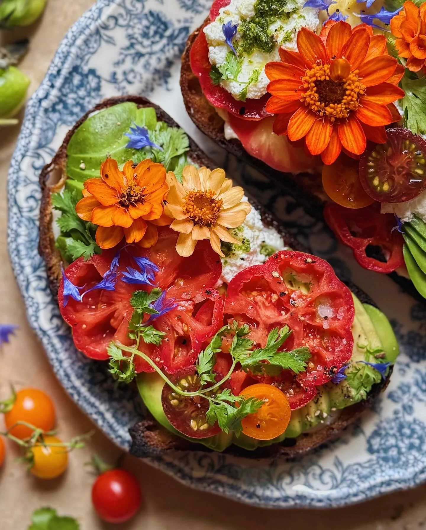 The perfect avocado toast combo for savoring the last full week of summer&mdash;sourdough pan-fried in olive oil and topped with toum (Lebanese garlic sauce), a sliced up avocado, heirloom tomato slices, cherry tomatoes, farmers cheese, pesto, cilant