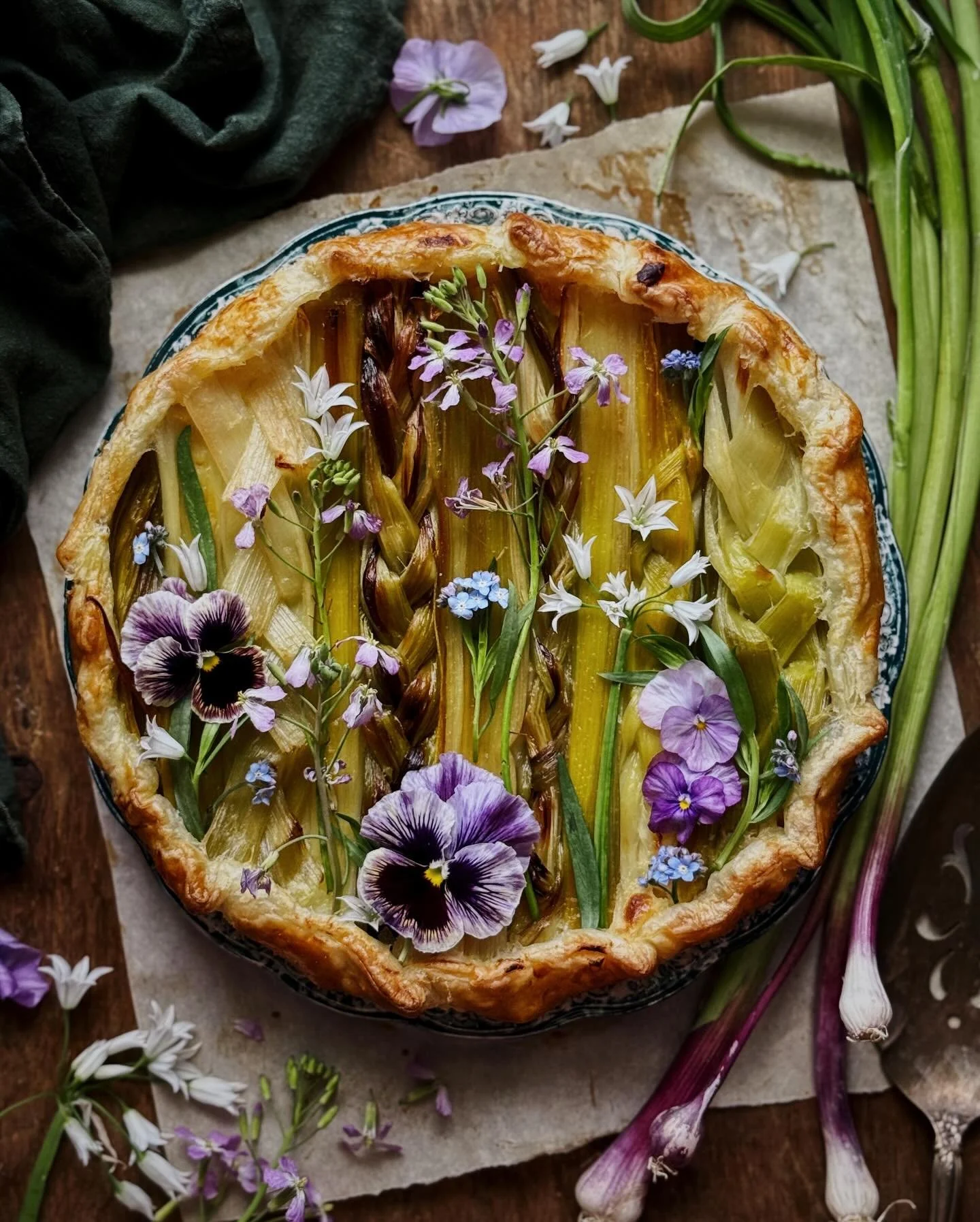 Leek, green garlic, and cheesy mashed potato tart with a hint of miso; decorated with tarragon, pansies, and edible wildflowers.⁣
⁣
Happy first day of spring to those who celebrate! I thought this tart was a perfect way to commemorate the transition 