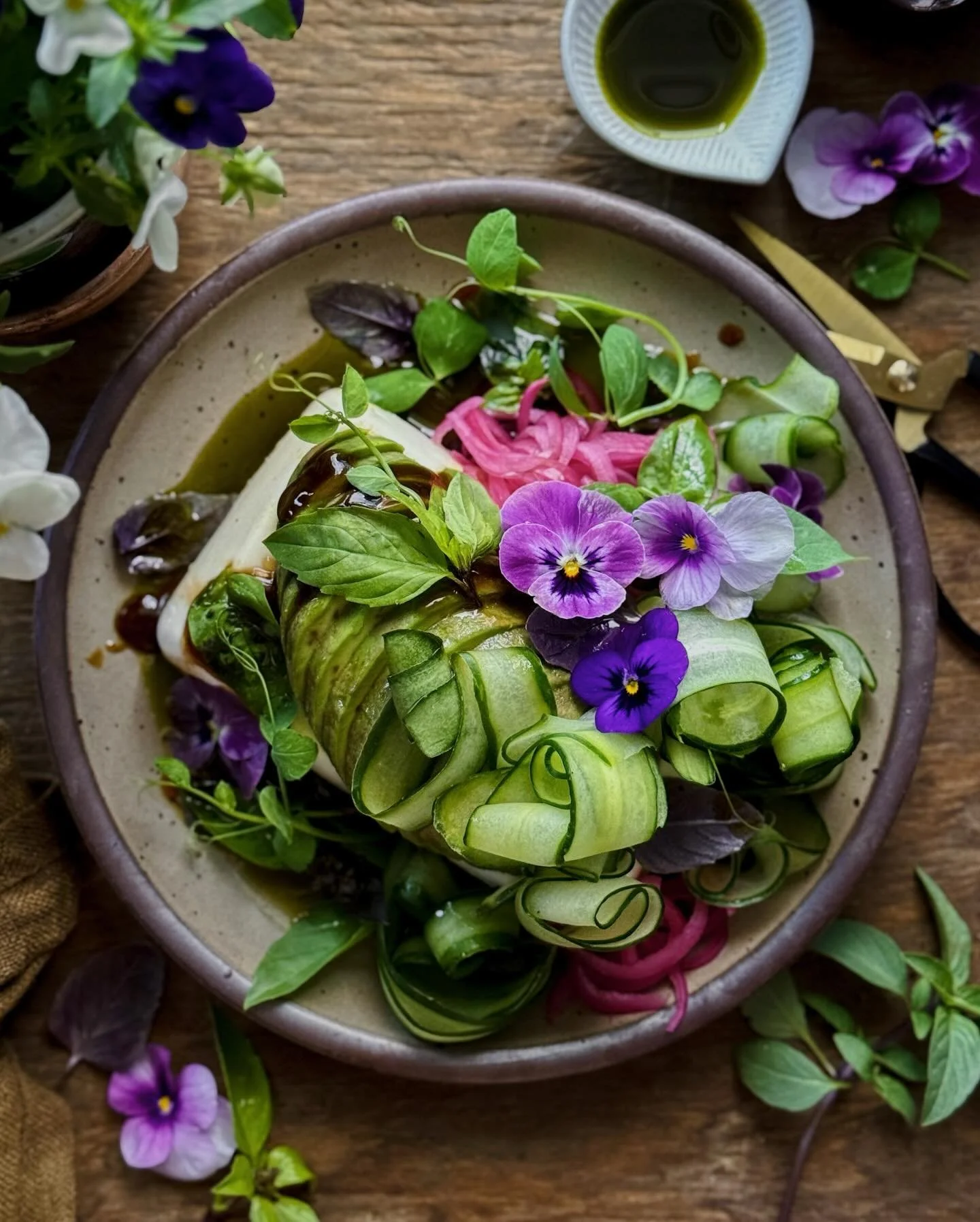 Custardy silken tofu and creamy avocado dressed with umami-rich oyster sauce and homemade toasted Thai basil oil. It&rsquo;s topped with ribbons of Japanese cucumber, bright and tangy quick-pickled onions, two types of beautiful basil, and pea tendri