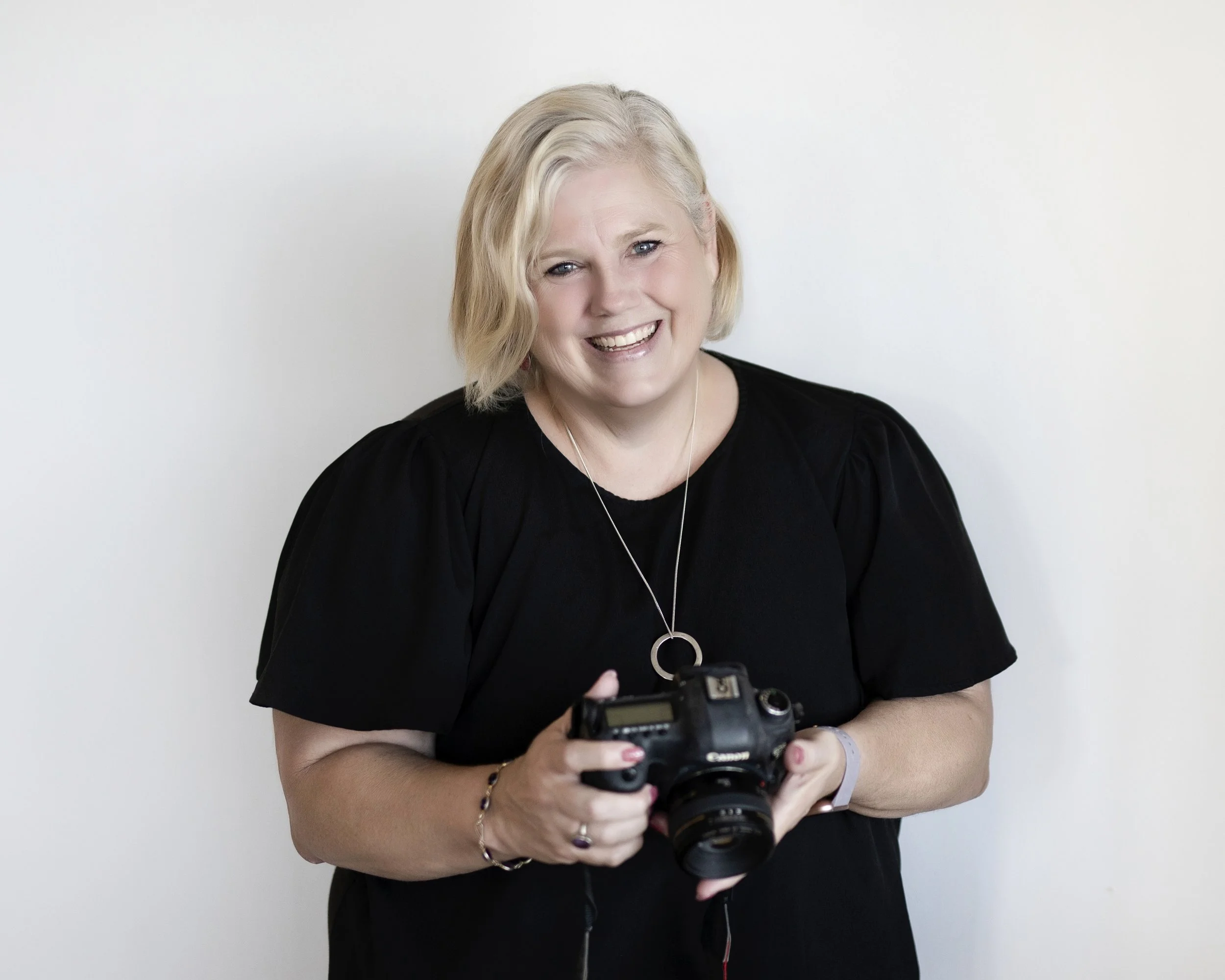 The owner of North Shore studio photographer Kate holding a camera