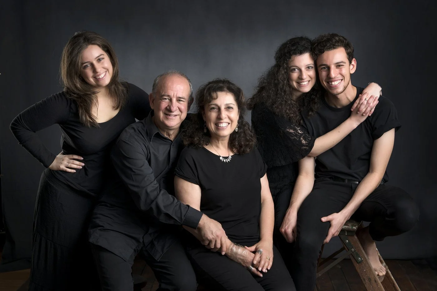 Mum, dad and their three adult children together in a moody studio portrait session in Sydney's North Shore