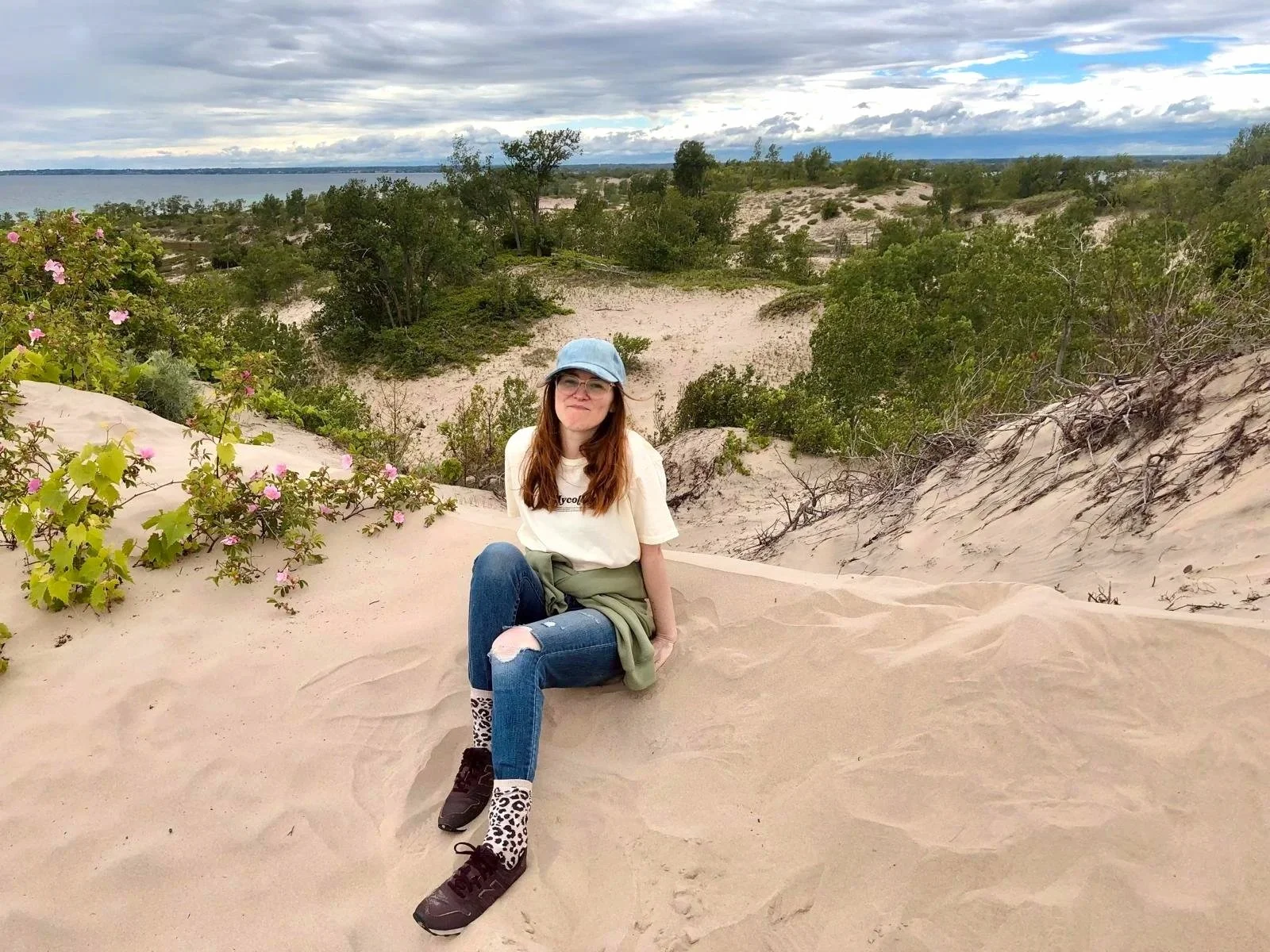 A beautiful woman poses for a photo on the sprawling dunes