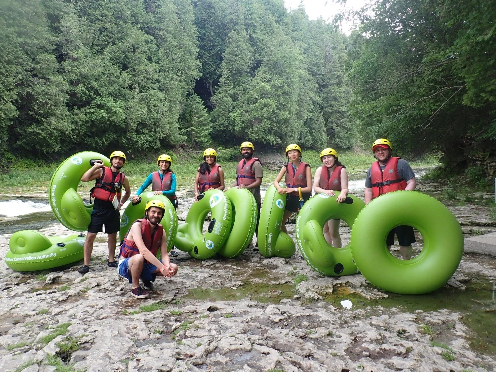 Group poses at river with tubes