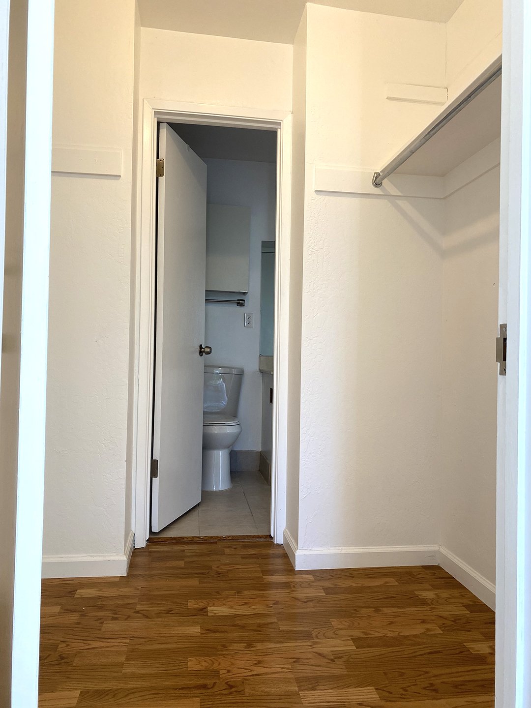 Walk-in closet between bed and bath