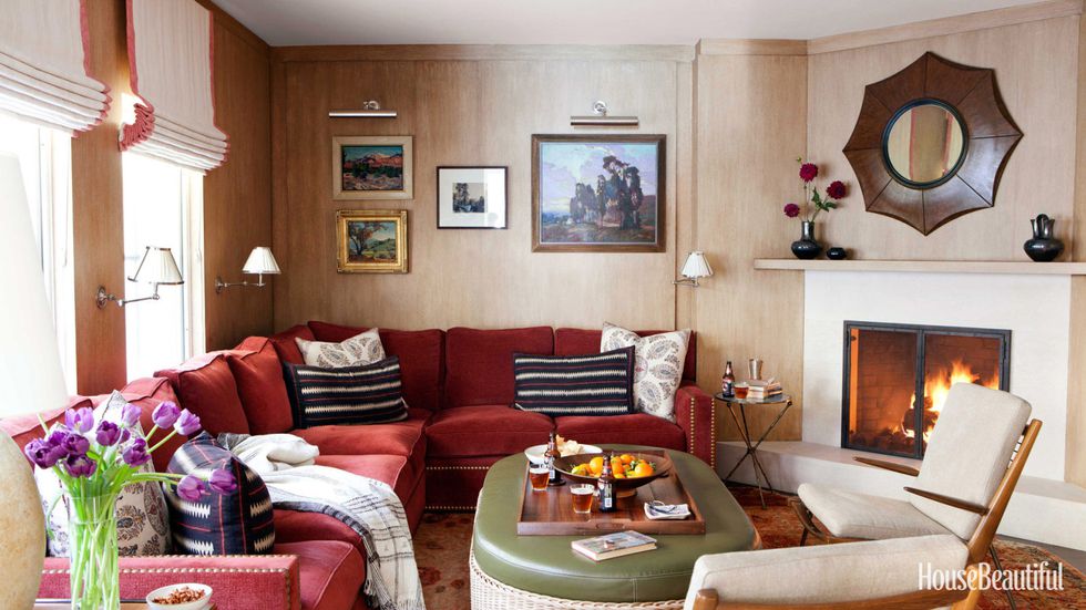 Wall Paneling "This was a dark room that was a bit stodgy and gloomy," Dunham says. "I thought, 'Let's go more cavelike.' So I paneled it in cerused white oak, inspired by Jean-Michel Frank." Anchoring the seating group is a storage ottoman with a cushion in Edelman leather from Dunham's store, Hollywood at Home . He designed the sectional sofa for the room and added vintage Peter Hvidt lounge chairs as a counterpoint: "You have to mix the notes. With all the solid upholstery, I wanted wooden pieces that were bony and sculptural." Walnut and ebony mirror from Reborn Antiques .