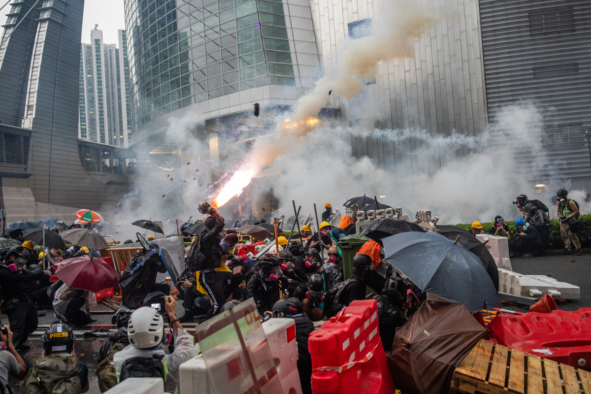 19.08.25 - Tsuen Wan, Hong Kong - An anti-government protestor jumps to catch a tear gas grenade as it explodes.