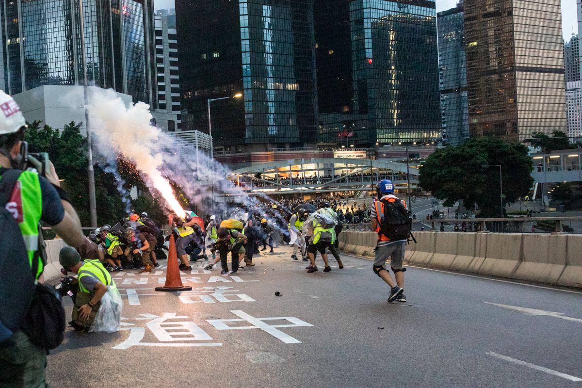 Tear gas grenade explodes over journalists.