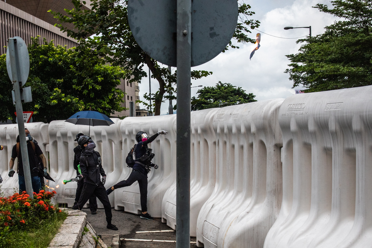 Protestors lobbing petrol bombs over the water barricades at government hq in Admiralty