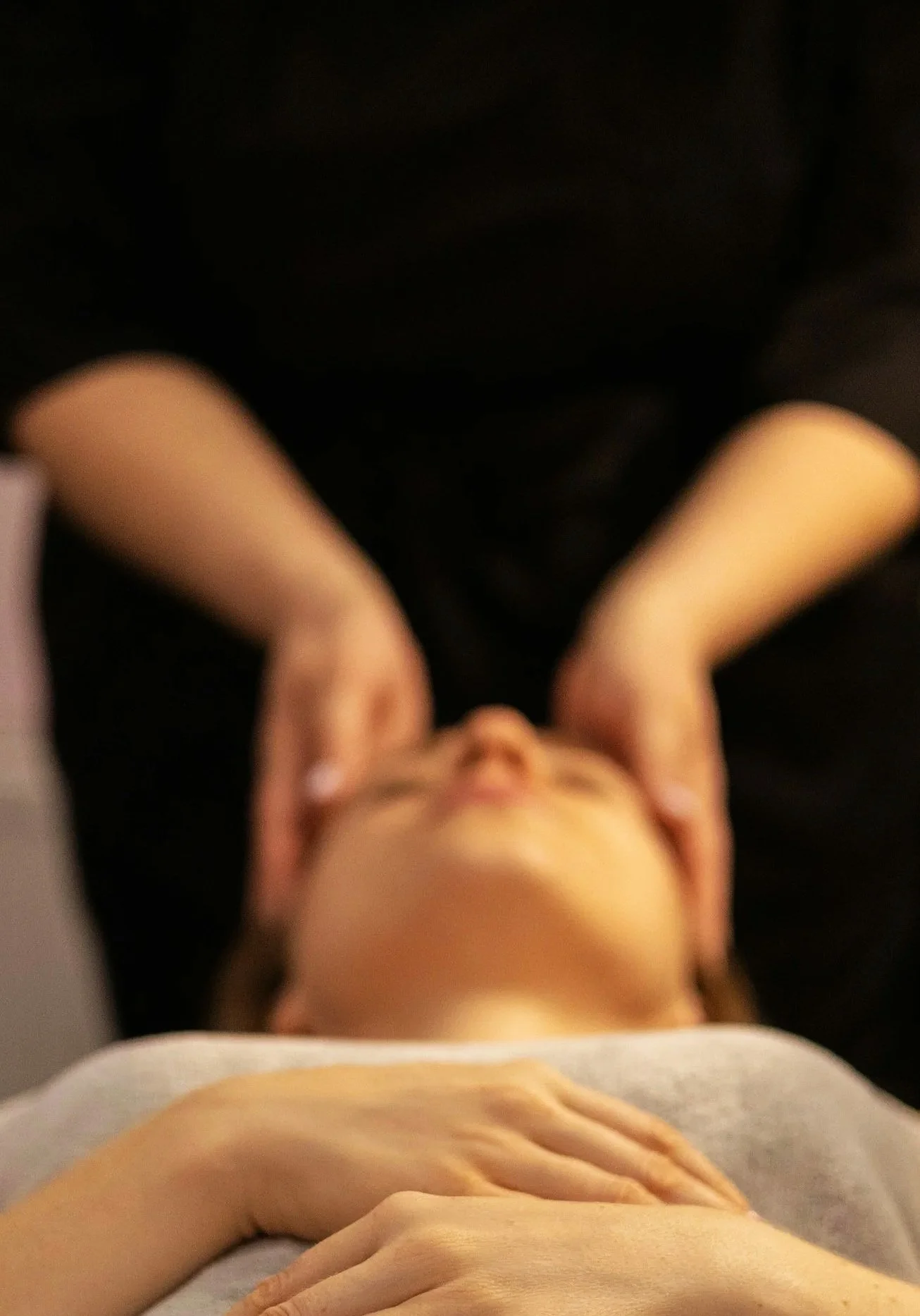 Image of woman cradling a client's head in craniosacral therapy