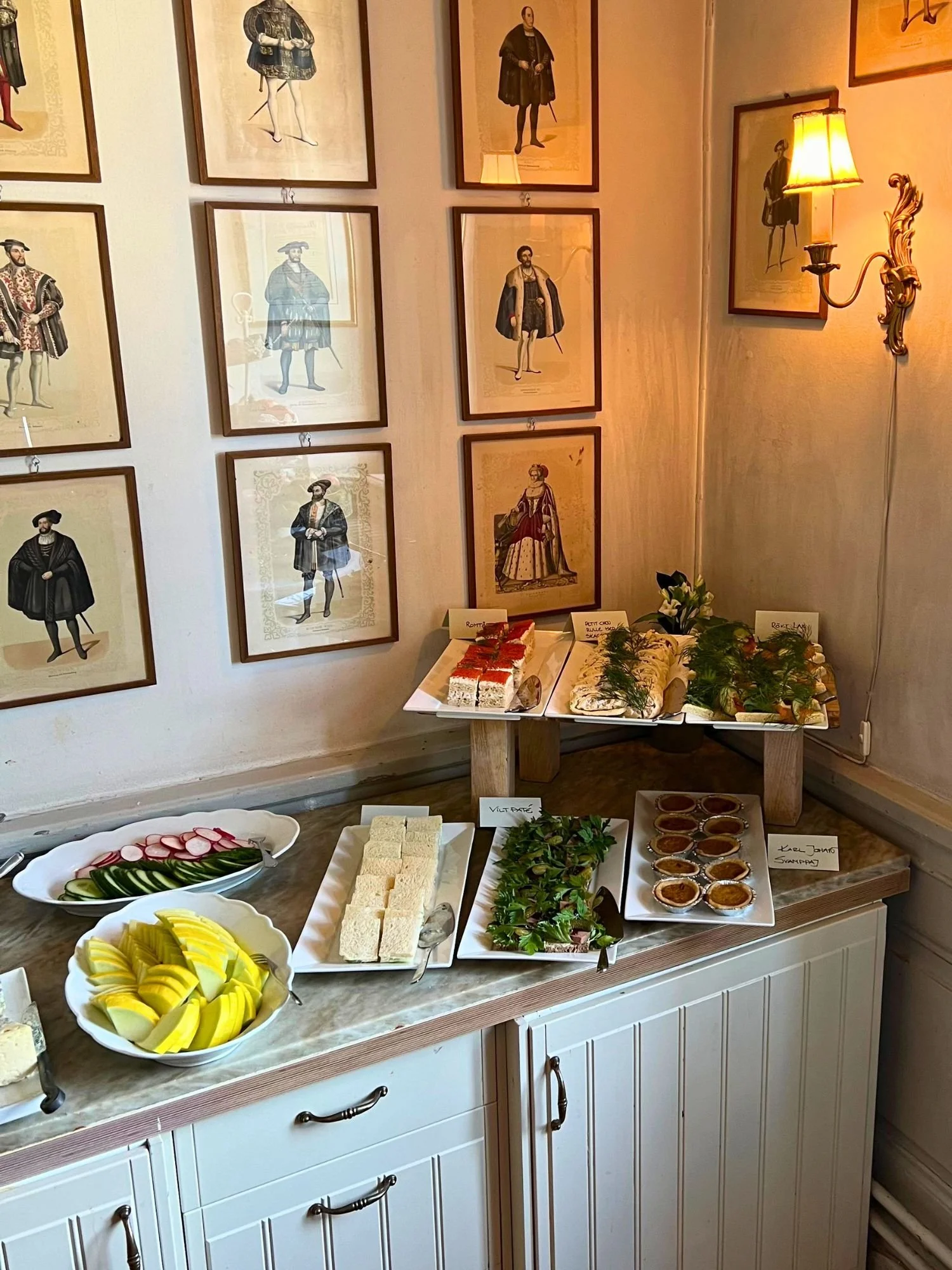 A buffet-style arrangement of savory snacks and sandwiches on a counter at afternoon tea at Vadstena Klosterhotel.
