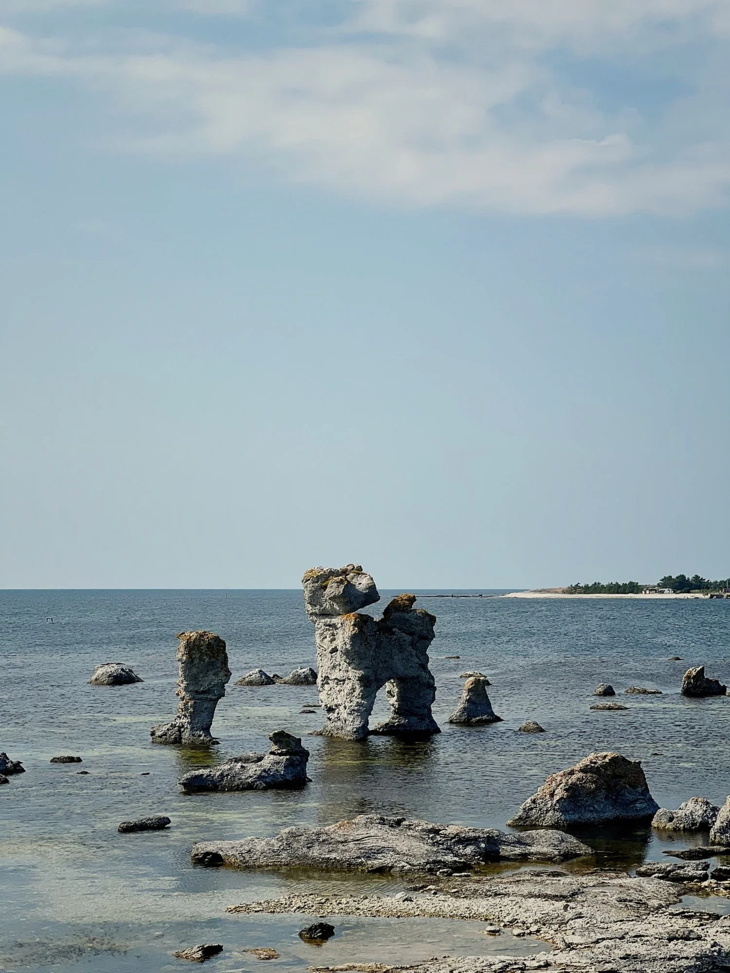 Several raukar (limestone stacks) in the shallow, turquoise waters of Gamla Hamn Naturreservat on the island of Fårö.