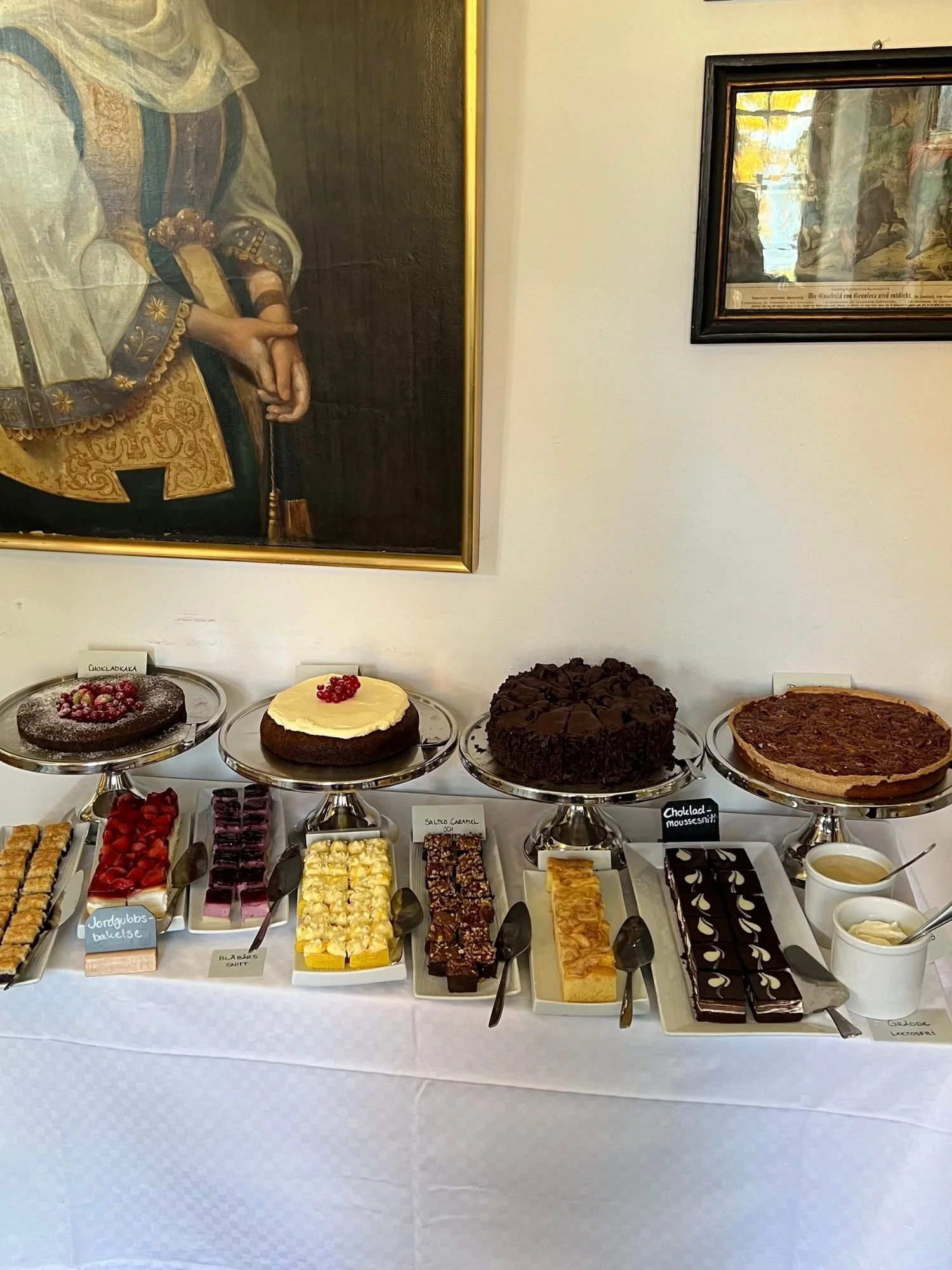 A dessert buffet table covered in a white tablecloth at Vadstena Klosterhotel.