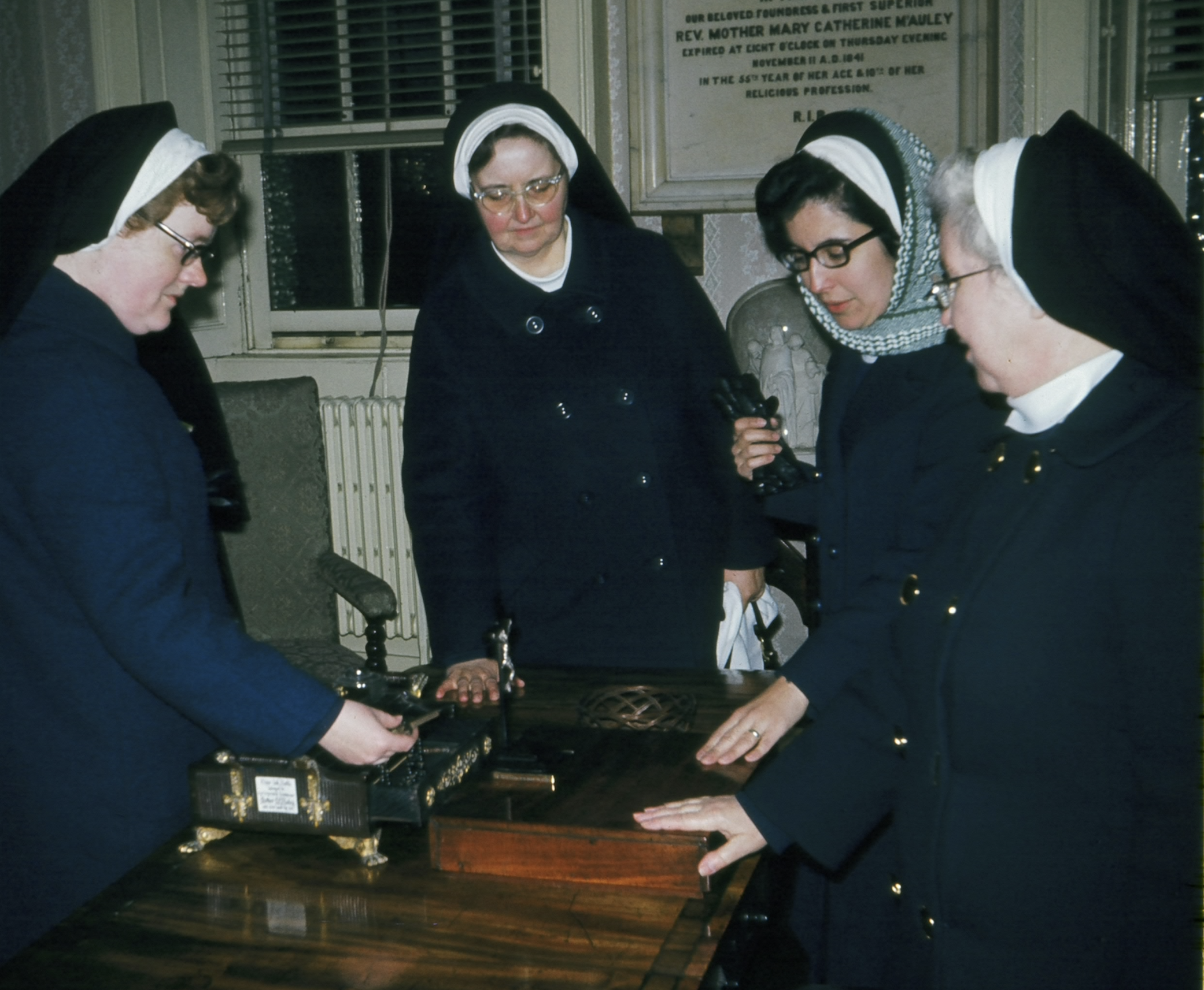 In the midst of the refoundation, the Founding Mothers of the Religious Sisters of Mercy of Alma, Michigan visited Baggot Street in Dublin, Ireland (Mother Catherine’s first foundation for the Sisters of Mercy). Here, four of them are at Mother Catherine McAuley’s writing desk, as she left it, in her room (the writing desk is also pictured above in the large image).