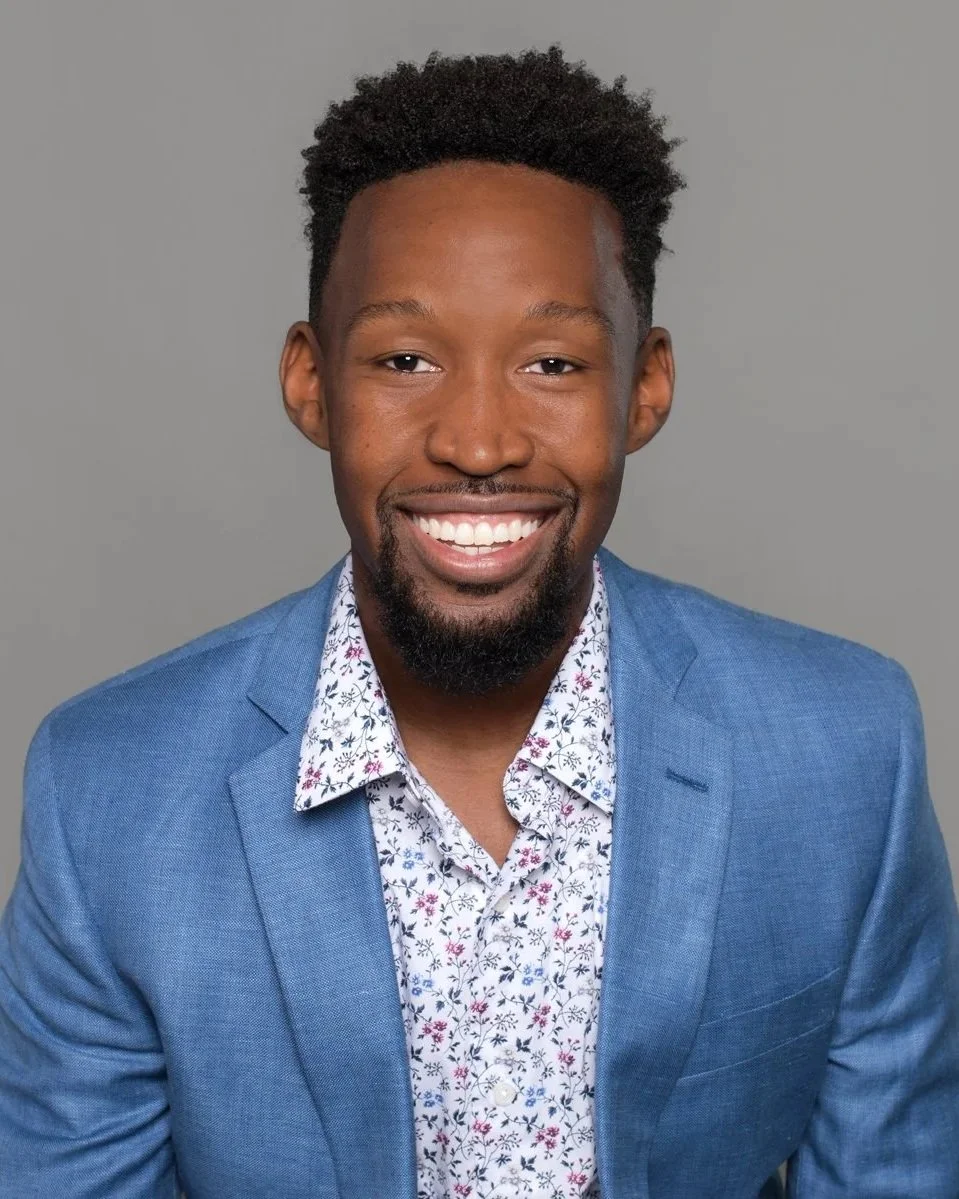 Professional headshot of a young man wearing a suit