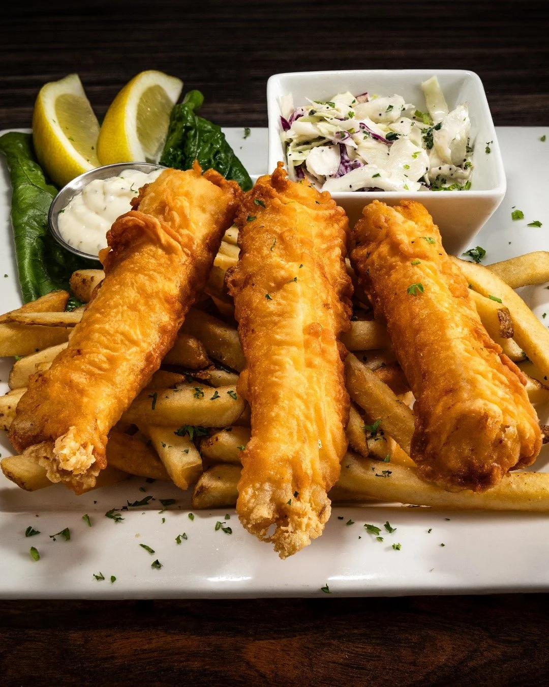Dive into the classic taste of our Traditional Fish 'N' Chips! 

Each piece is hand-battered in-house, ensuring a crispy, golden perfection. Served with our signature pub fries and a side of coleslaw for that authentic pub experience. 

It&rsquo;s a 