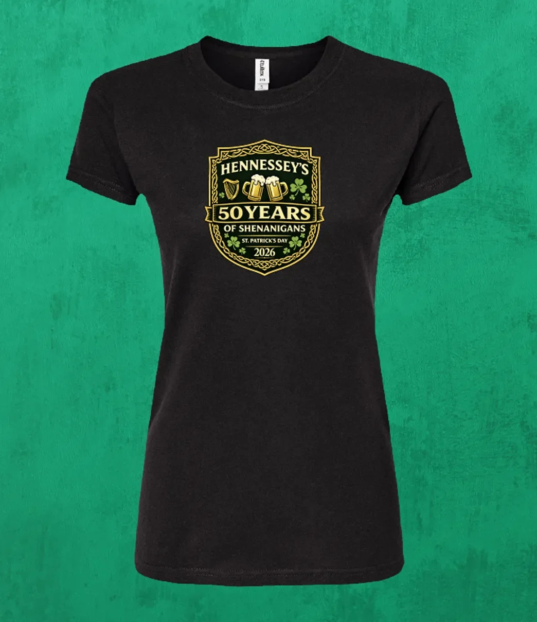 Black women’s T-shirt featuring the Hennessey’s Tavern “50 Years of Shenanigans” St. Patrick’s Day 2026 crest with shamrocks and Irish-themed icons.