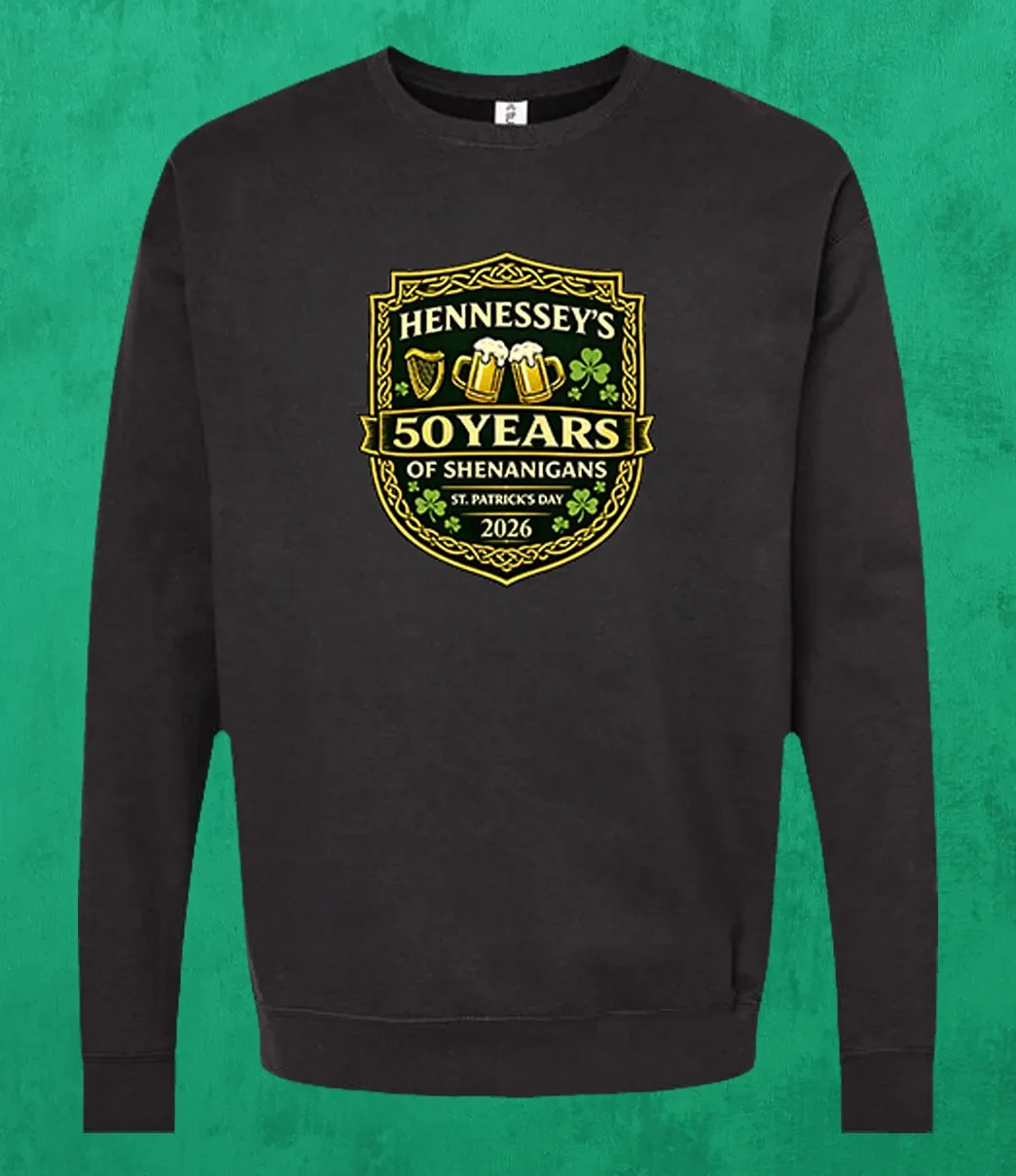 Black unisex crewneck sweatshirt featuring the Hennessey’s Tavern “50 Years of Shenanigans” St. Patrick’s Day 2026 crest with shamrocks and Irish-themed icons.