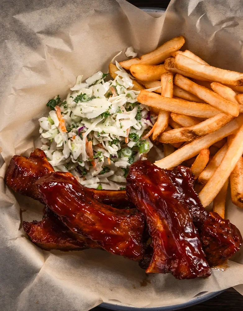 All-you-can-eat ribs with fries and coleslaw served in a basket at Hennessey’s Tavern during Monday night special.