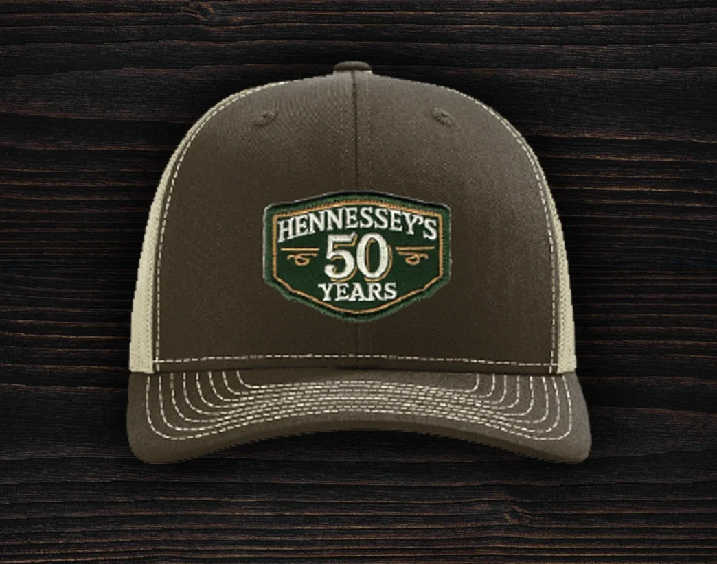 Brown trucker hat featuring an embroidered Hennessey’s Tavern 50 Years anniversary logo patch on the front panel