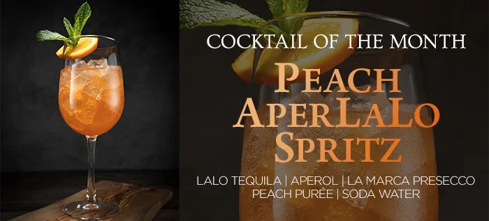Hennessey's Peach AperLALO Spritz featuring LALO Tequila, Aperol, La Marca Prosecco, peach purée, and soda water, garnished with mint and an orange slice.