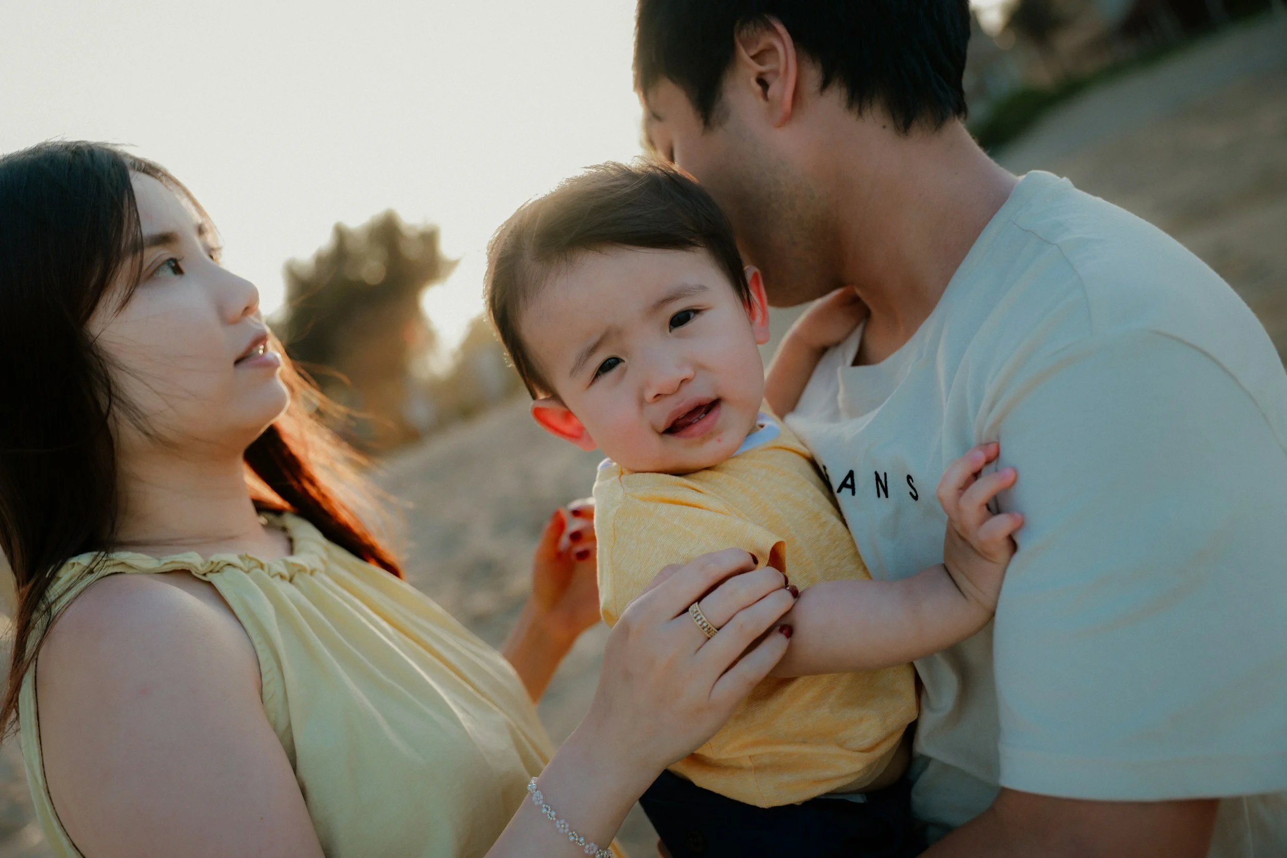 Child in between the arms of the mother and father during child custody investigation in White Plains
