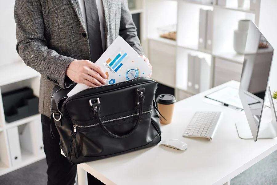 Man placing company documents in a bag while under investigation for business fraud in Greenwich, CT