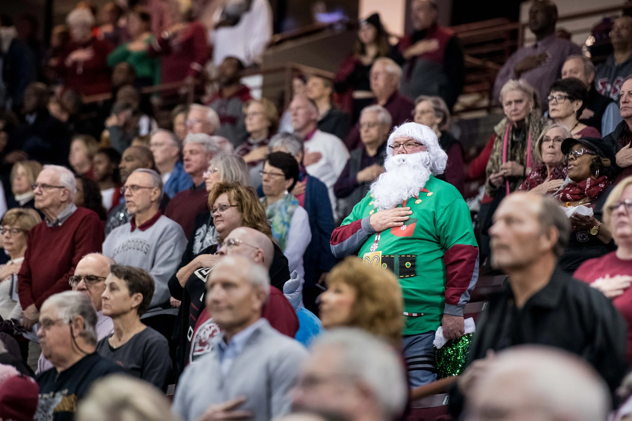 Basketball fans stand for the natonal anthem