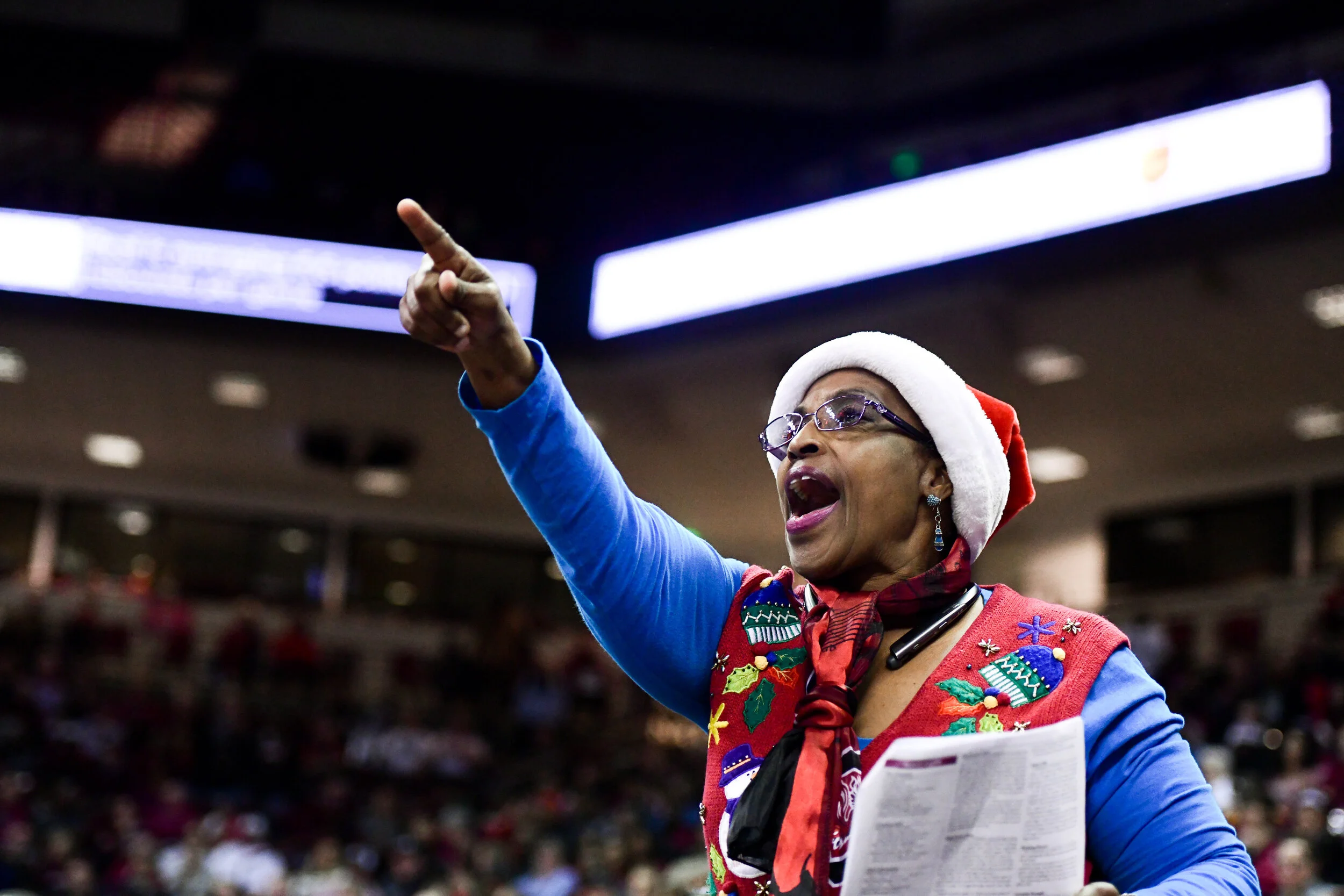 A basketball fan wearing holiday clothing sheerrs on her team