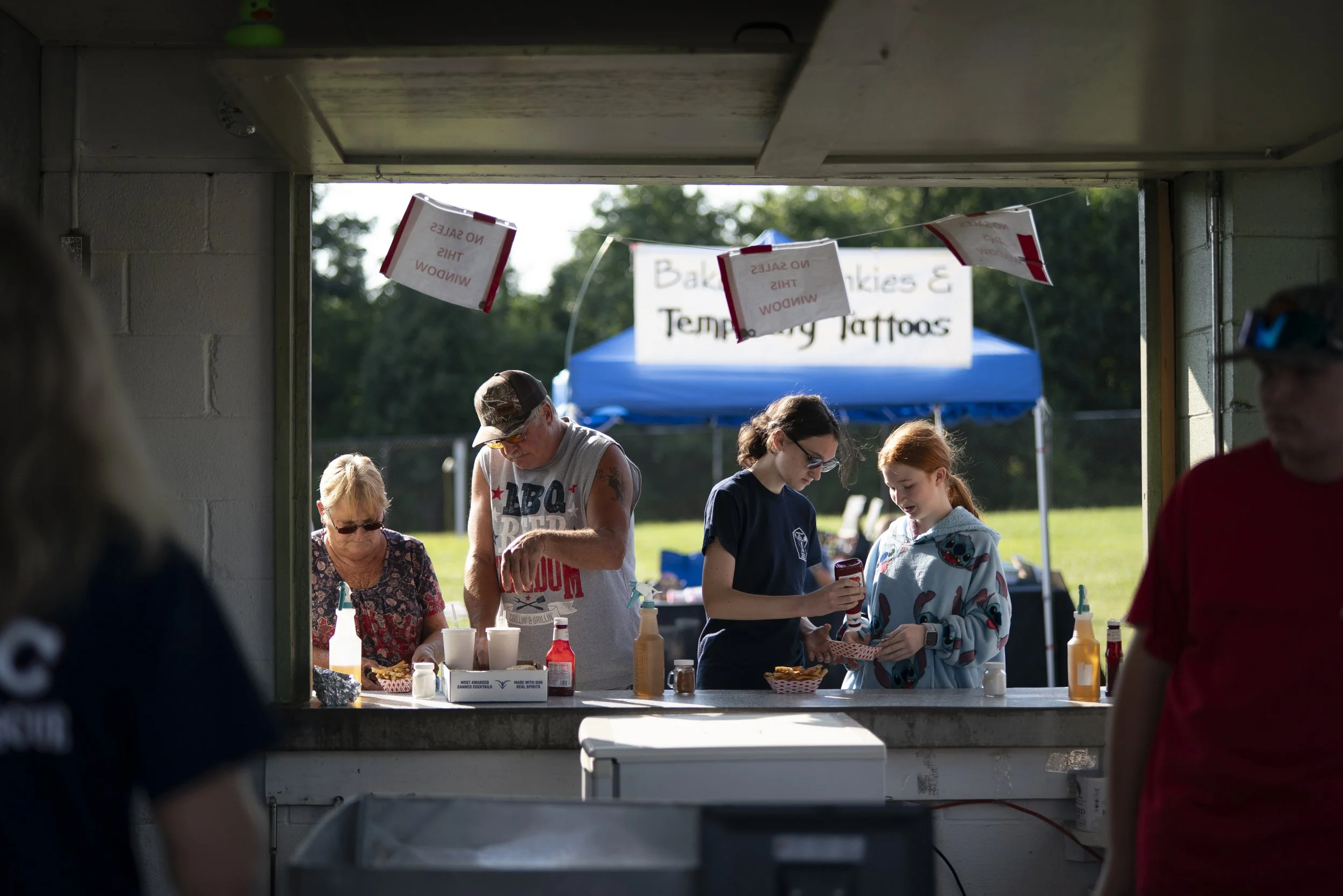 People put condiments on food at the Mt. Airy Carnival