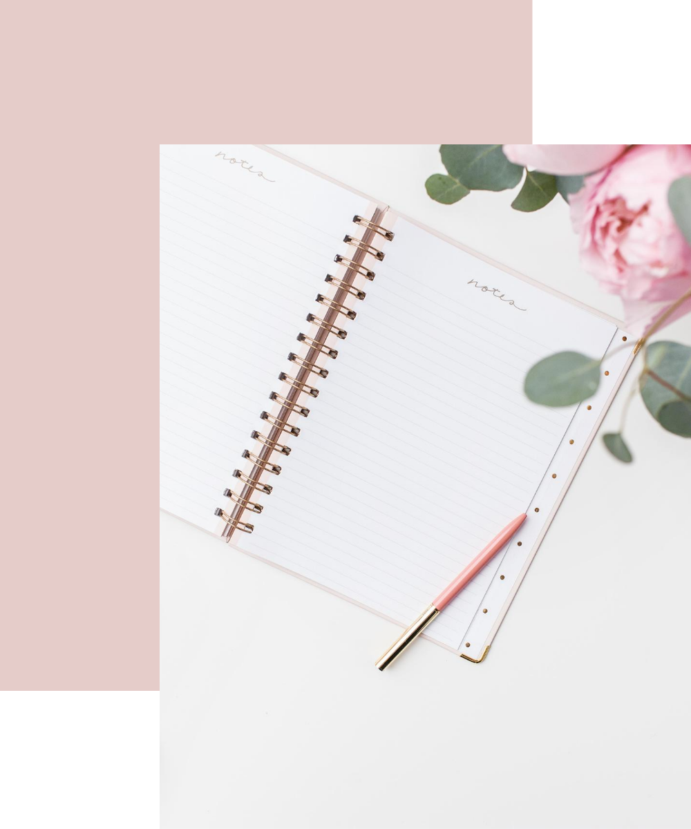 Notebook with lined pages and a pink pen, surrounded by greenery, symbolizing organization and productivity for time management consulting services.
