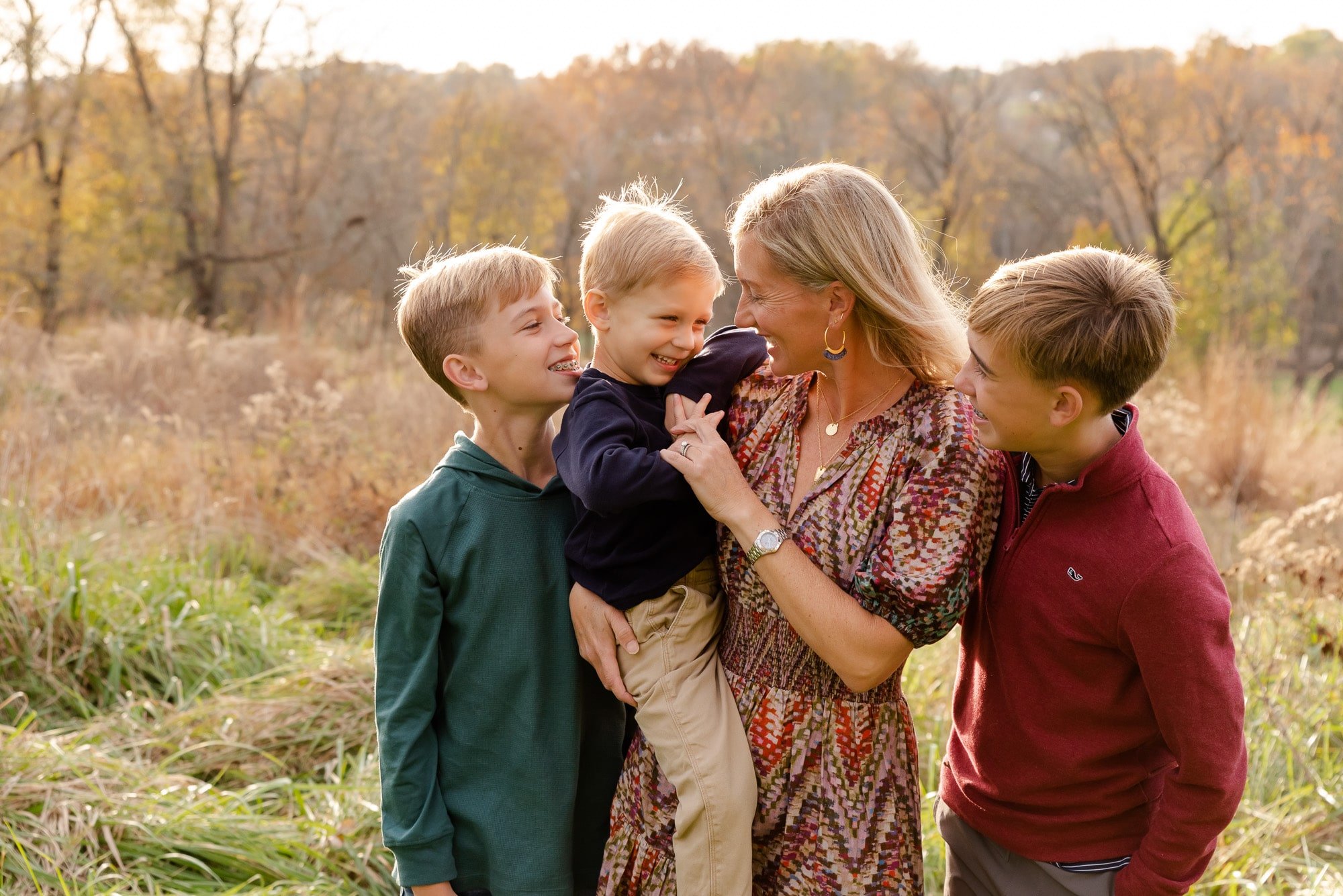 mother snuggling sons in field St. Louis Family Photography sarahrowlandphotography.com