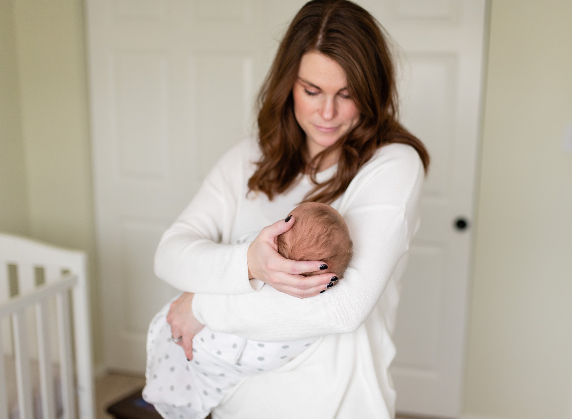 mother with newborn in nursery  St. Louis Newborn Photography sarahrowlandphotography.com