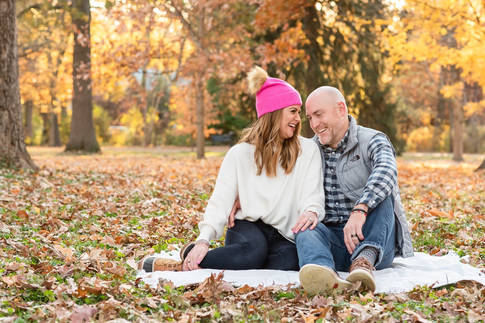 couple snuggled in park on blanket