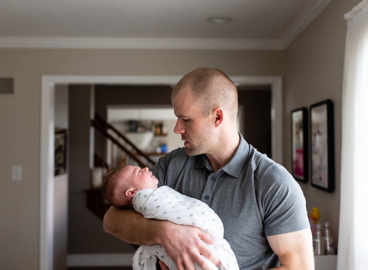 father holding newborn baby in hall  St. Louis Newborn Photography sarahrowlandphotography.com