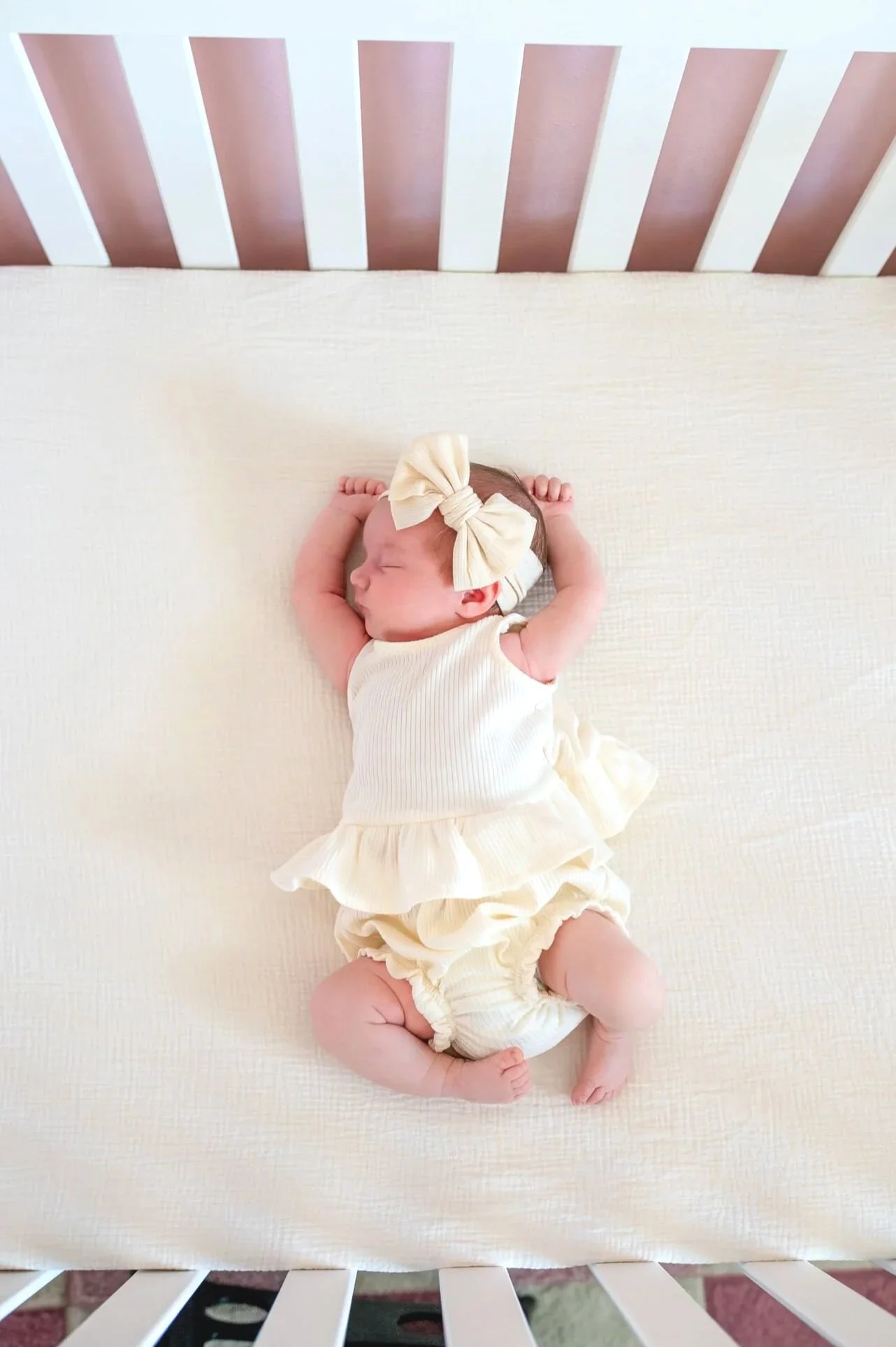 newborn stretching in crib with bow_SRP_3680+.jpg