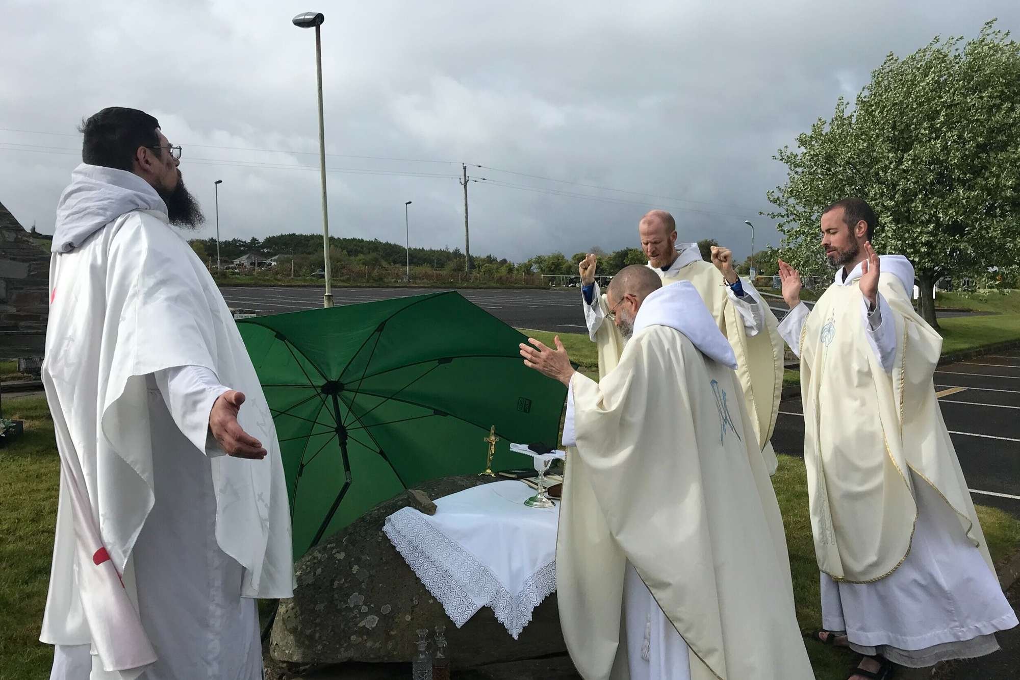 Franciscan friars celebrate Mass together at an outdoor stone altar